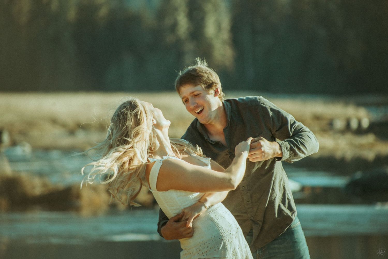 A couple dances together at sunset by a lake, with the man dipping his partner in a romantic pose in Southeast Alaska.