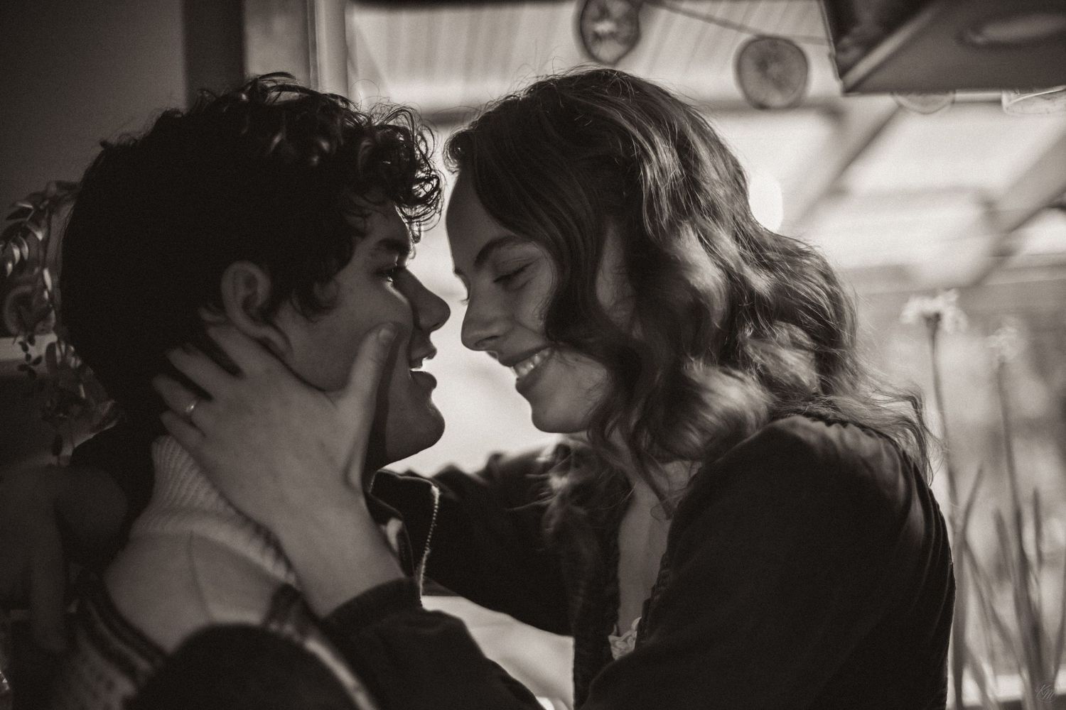 A romantic black and white portrait shows a couple in an intimate moment, with soft lighting and vintage styling in Southeast Alaska.