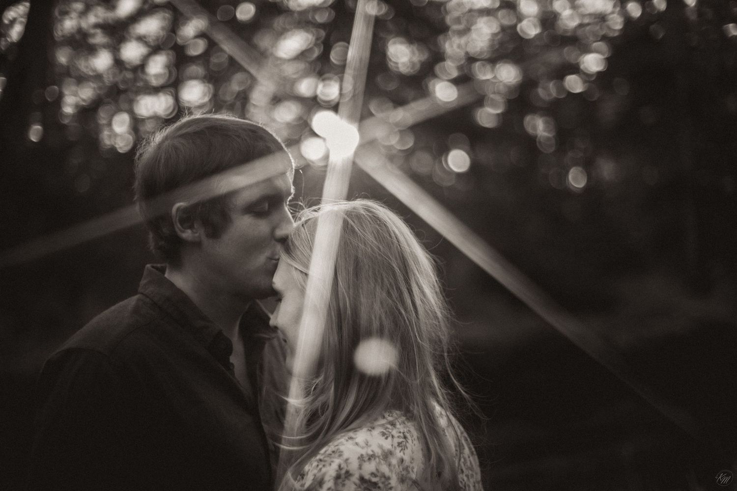 Romantic couple illuminated by bokeh lights share an intimate moment in black and white photography in Southeast Alaska