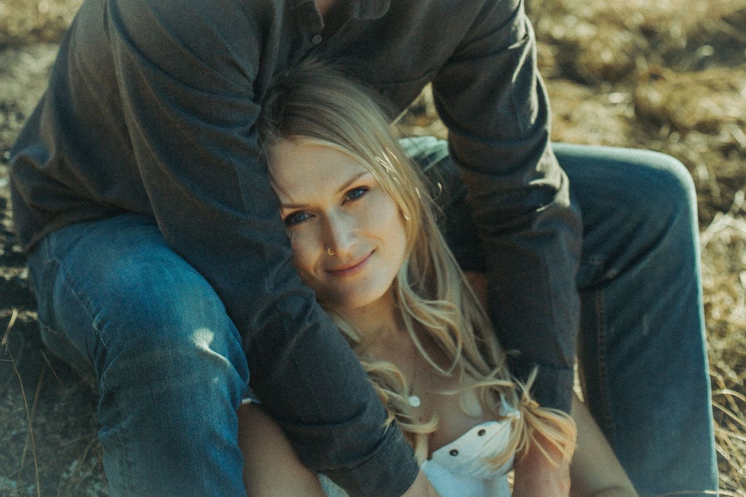 A person in casual denim clothing sits outdoors in a warm natural light setting in Southeast Alaska.