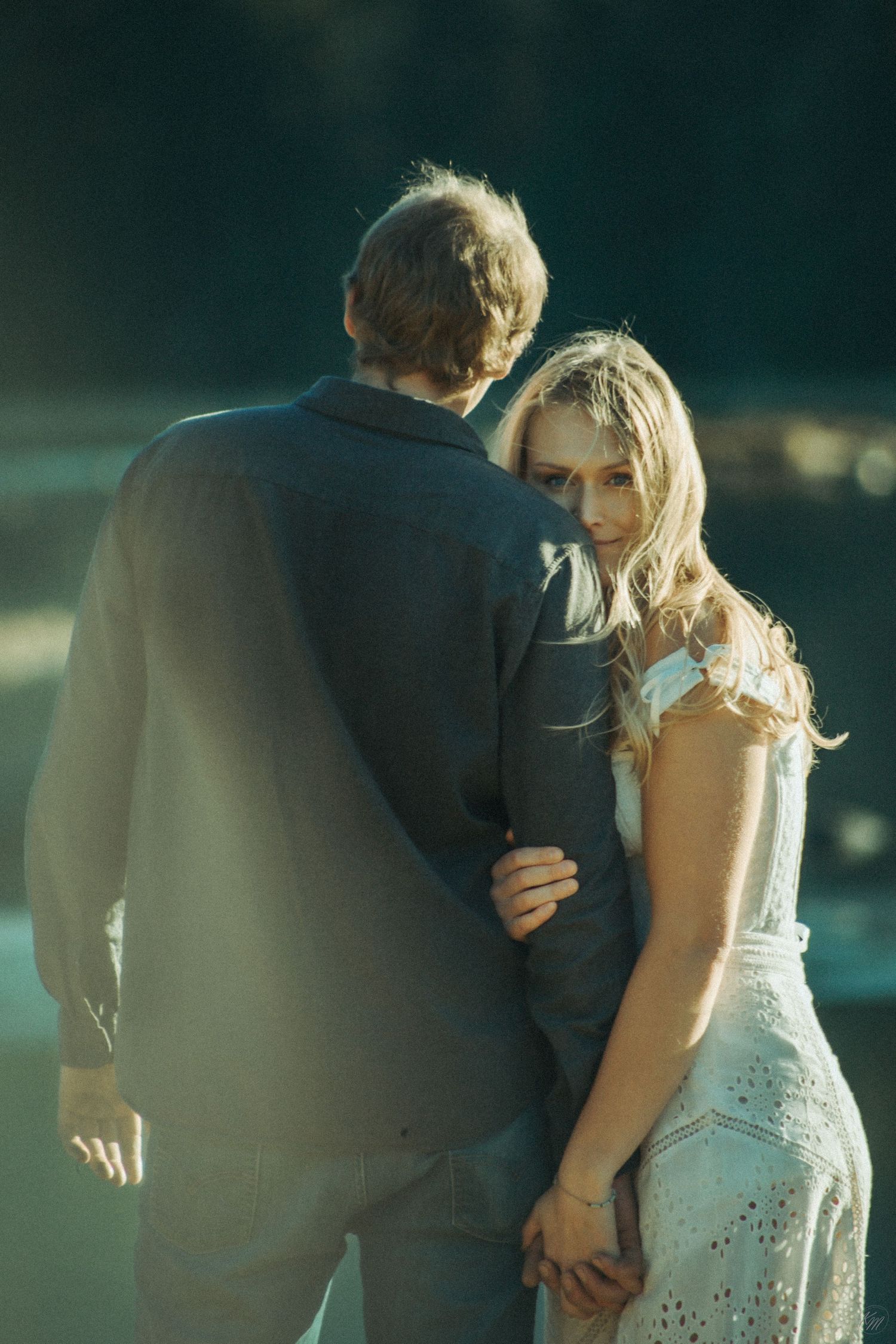 A romantic outdoor portrait shows a couple in wedding attire sharing an intimate moment in soft natural light in Southeast Alaska.