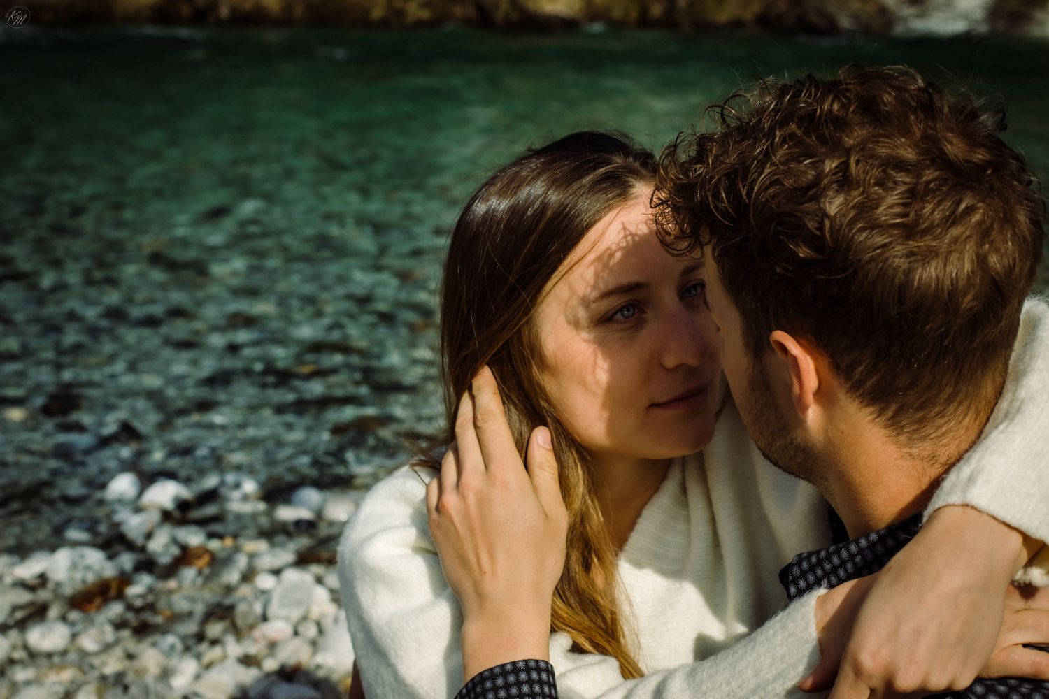Romantic couple embracing against mountain backdrop in dramatic black and white sequence.