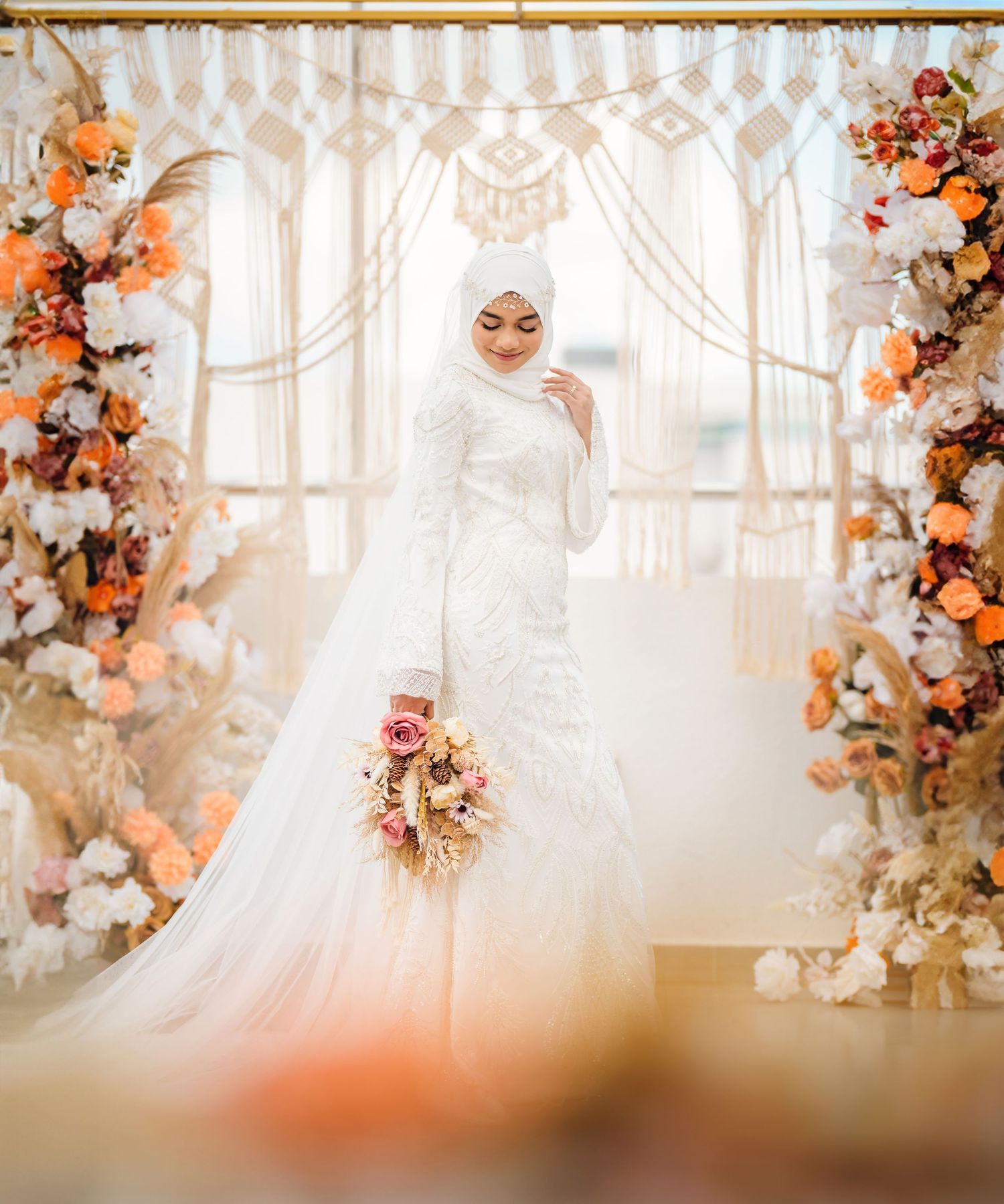 Elegant wedding setup with hanging crystal decorations and peach-colored floral arrangements.