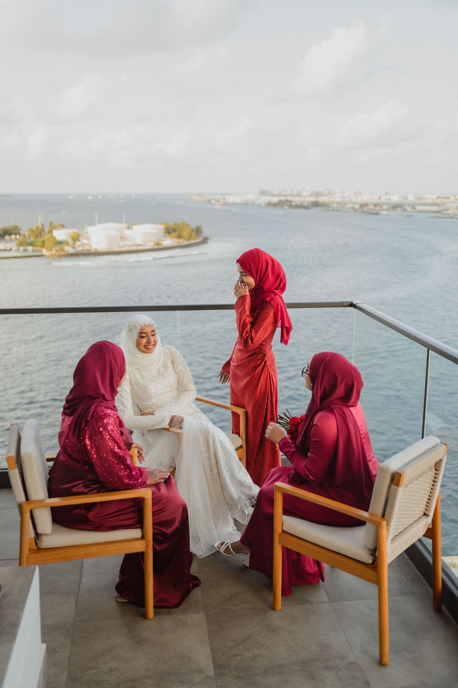 Group seated on waterfront terrace with ocean view in background.