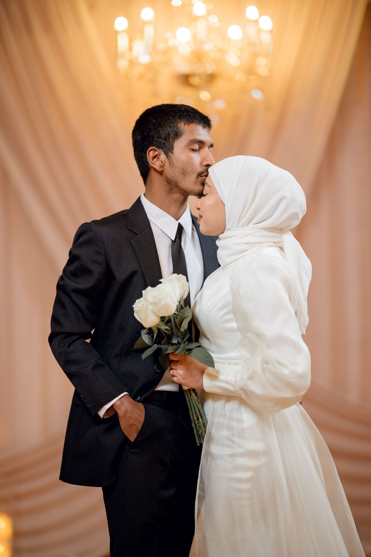 Intimate wedding dance sequence with white dress and black suit against warm lighting.