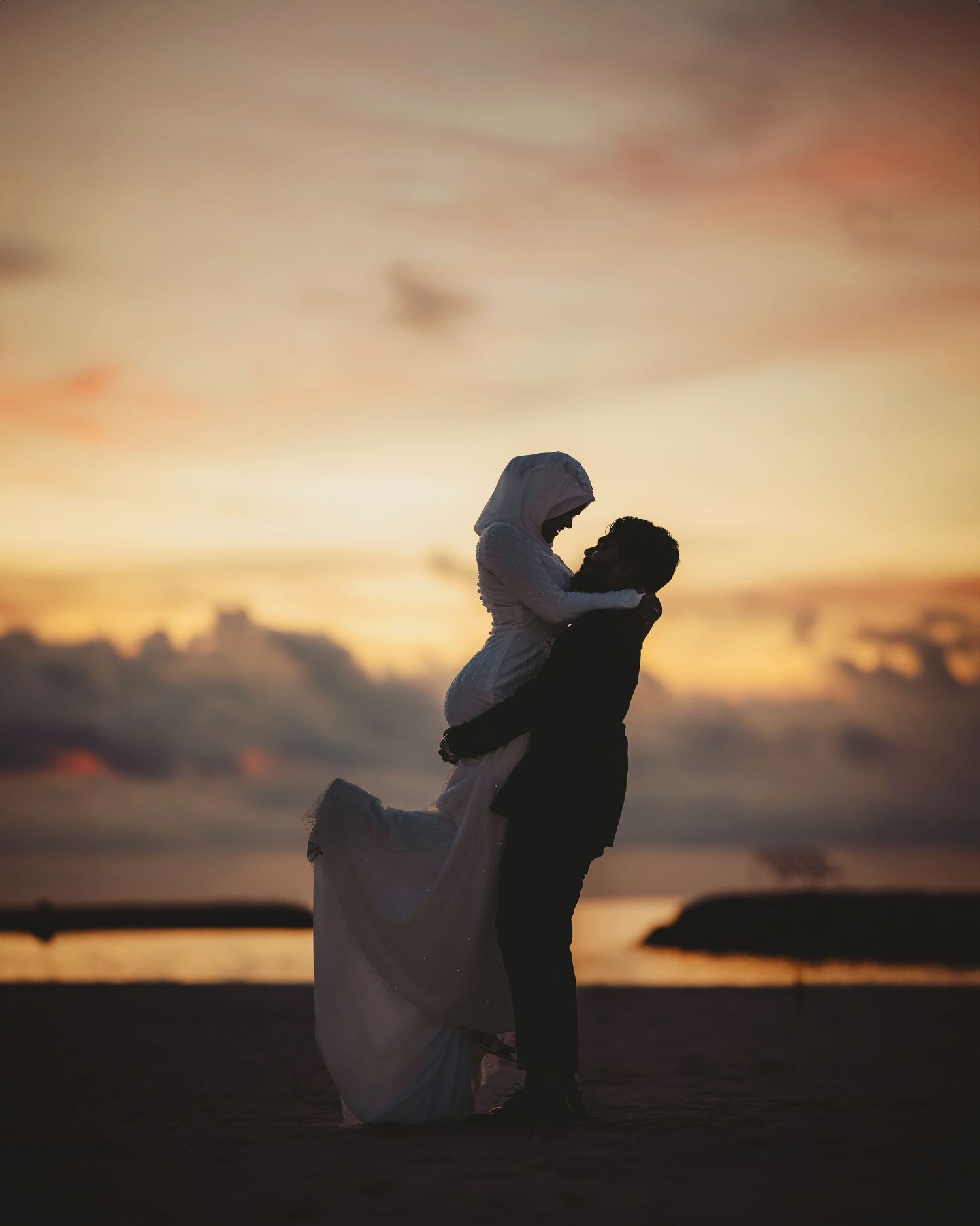 Romantic silhouettes of newlyweds during sunset beach photo session.