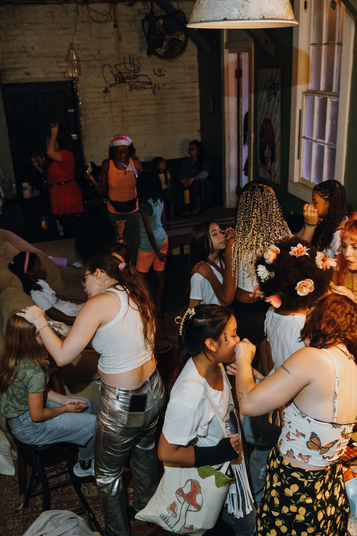 Young women socialize and dance together at a lively indoor party with vintage decor. New Orleans, Louisiana, Mississippi