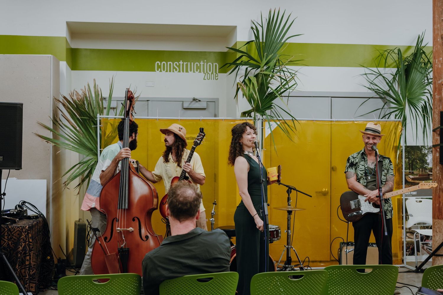 Live band performs on stage with double bass and guitar at an indoor community venue.