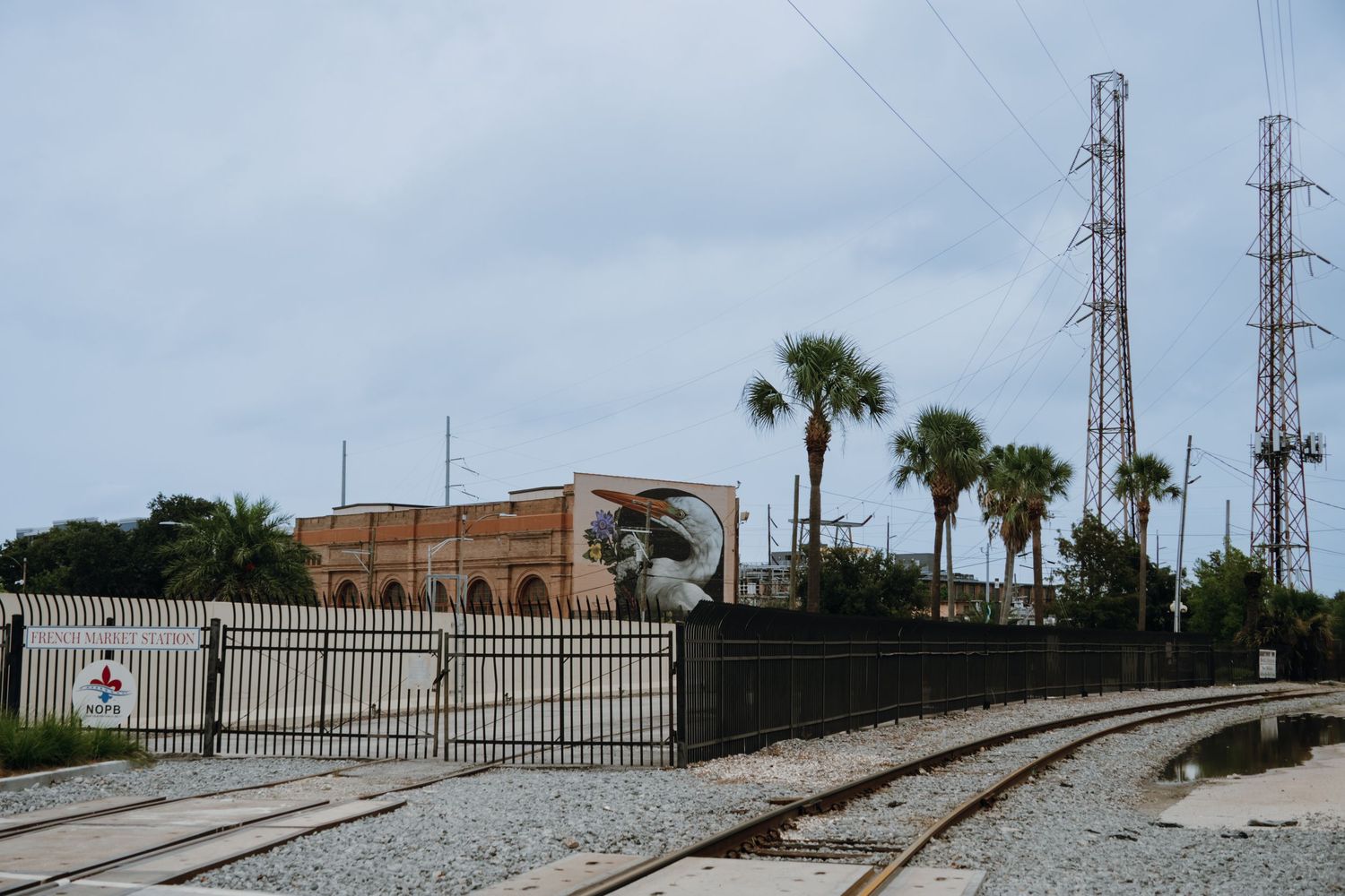 Railroad tracks leading to an industrial building with palm trees and power towers.New Orleans, Louisiana, Mississippi