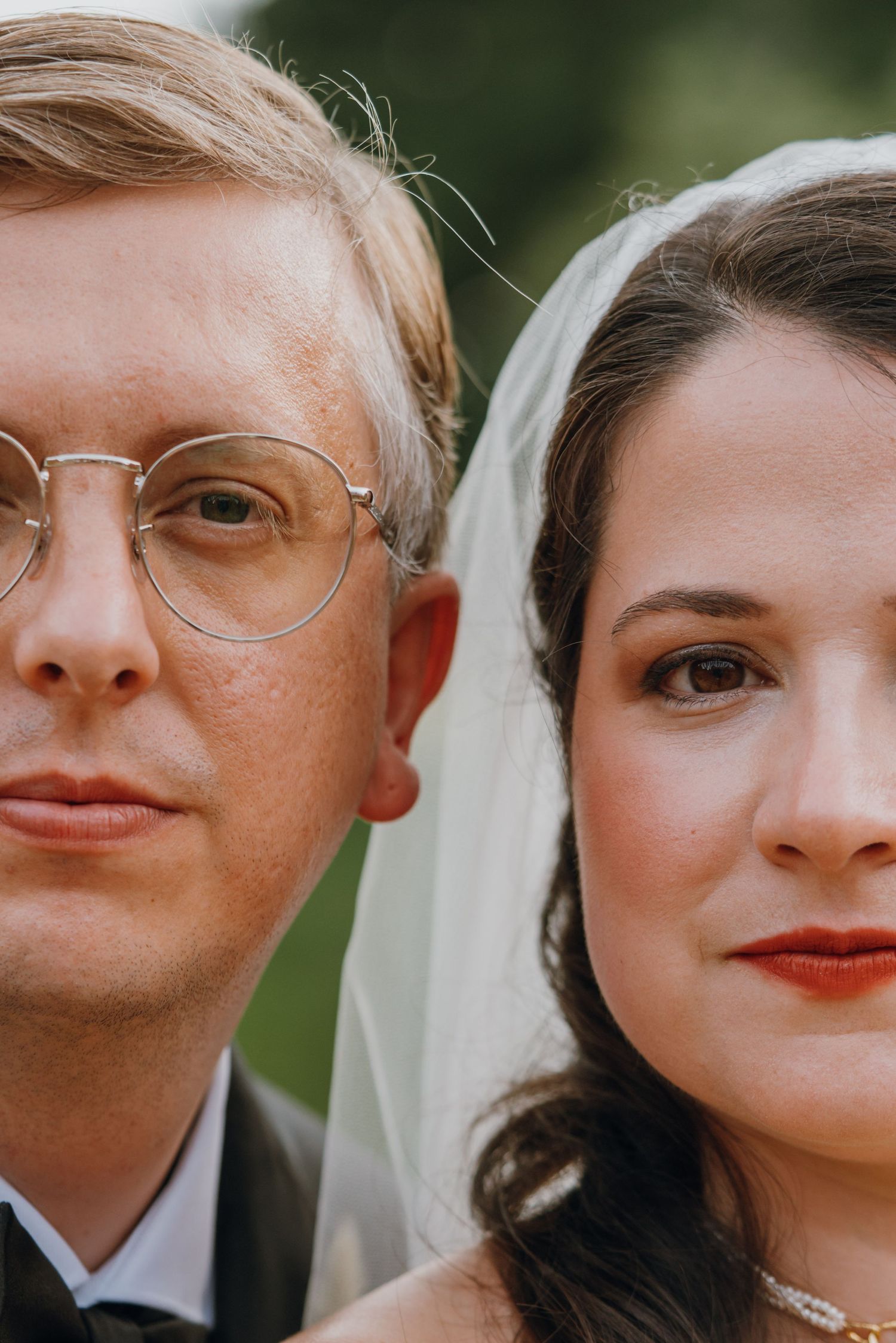 Close-up portrait of a bride and groom on their wedding day, groom wearing round glasses and bride in a veil. New Orleans, Louisiana, Missis