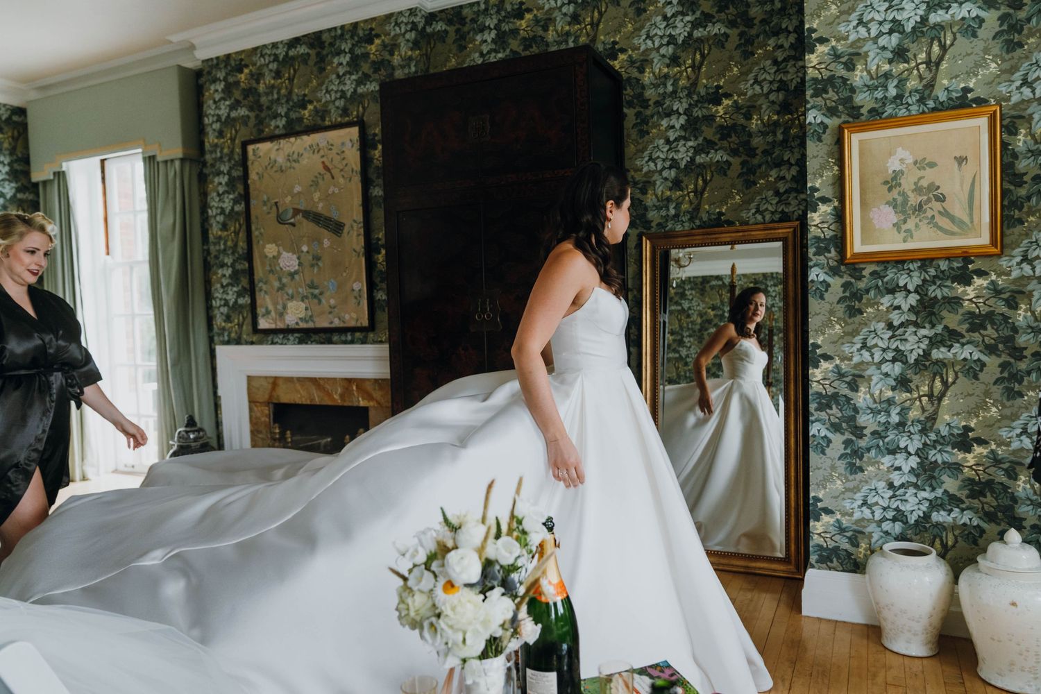 Bride in a full ballgown wedding dress admiring her reflection in a mirror with floral wallpaper. New Orleans, Louisiana, Mississippi