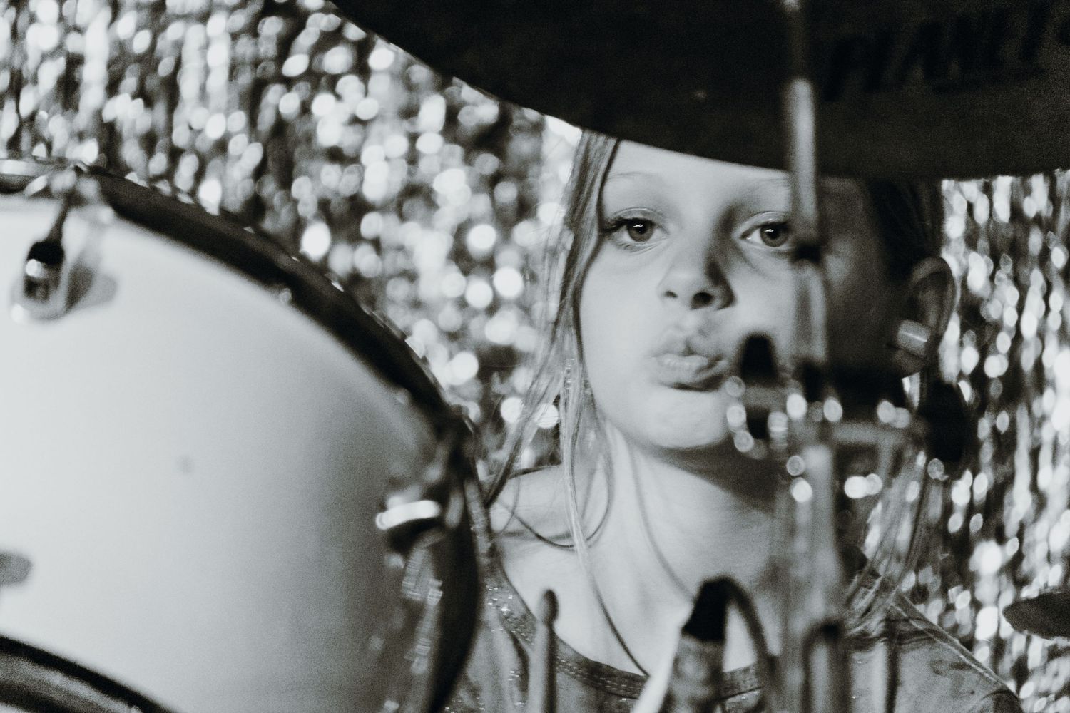 Black and white photo of a young girl playing drums at a live music performance. New Orleans, Louisiana, Mississippi