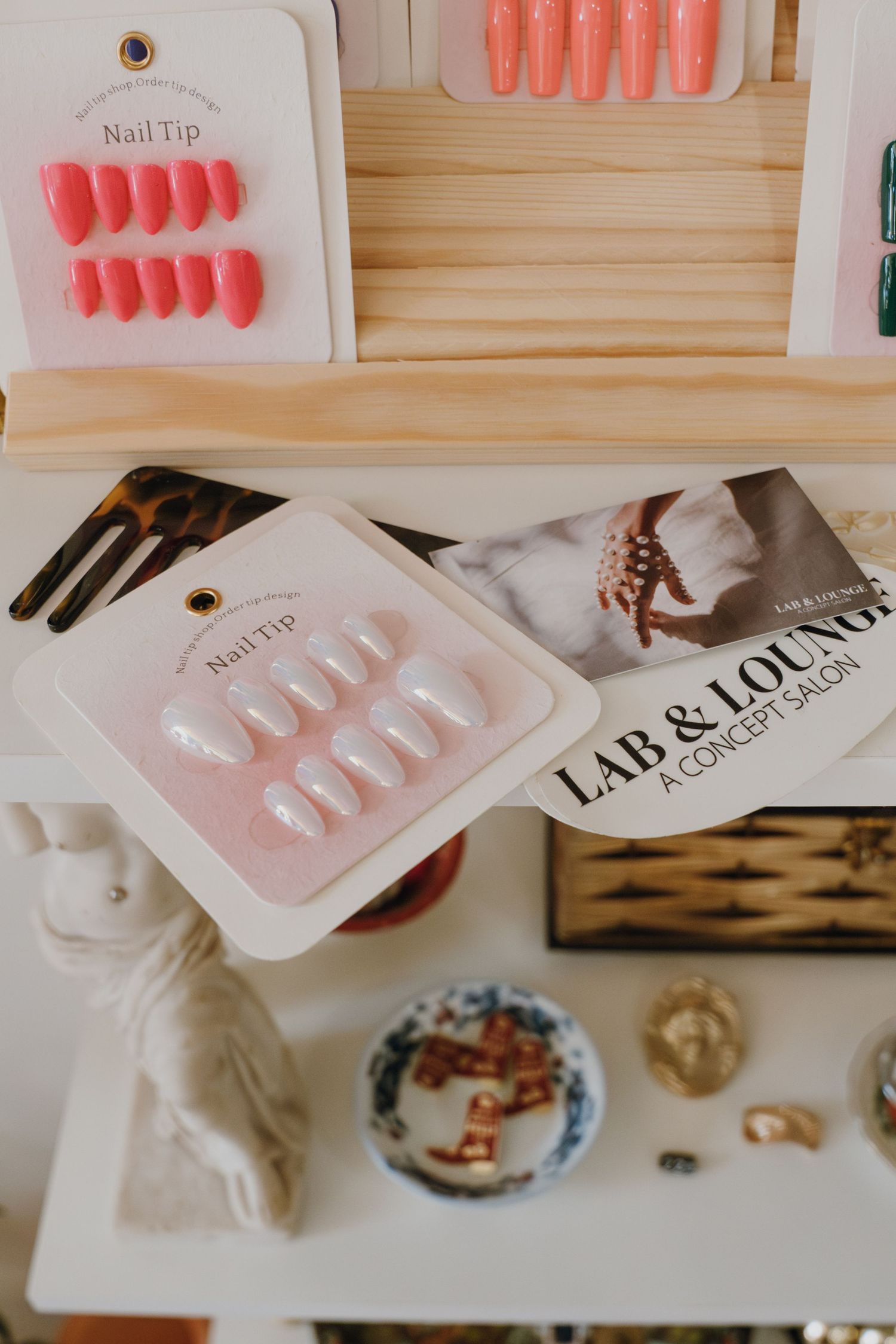 Lab & Lounge concept salon nail tip display with press-on nails and branded brochure.