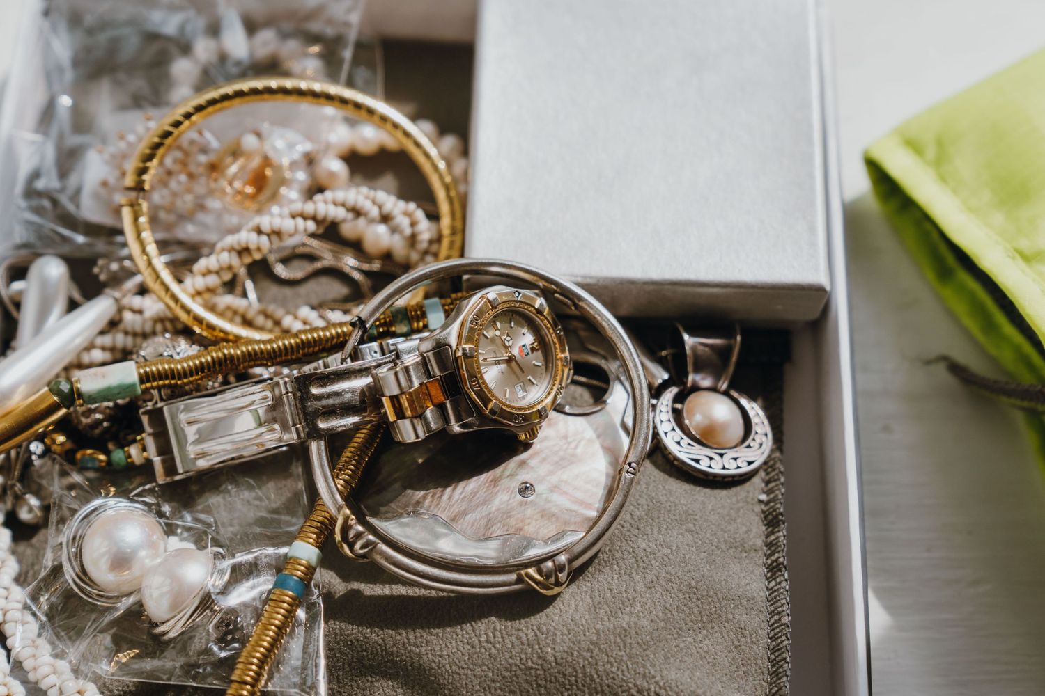 Collection of gold and silver jewelry including watches, bracelets, and necklaces in a jewelry box. New Orleans, Louisiana, Mississippi