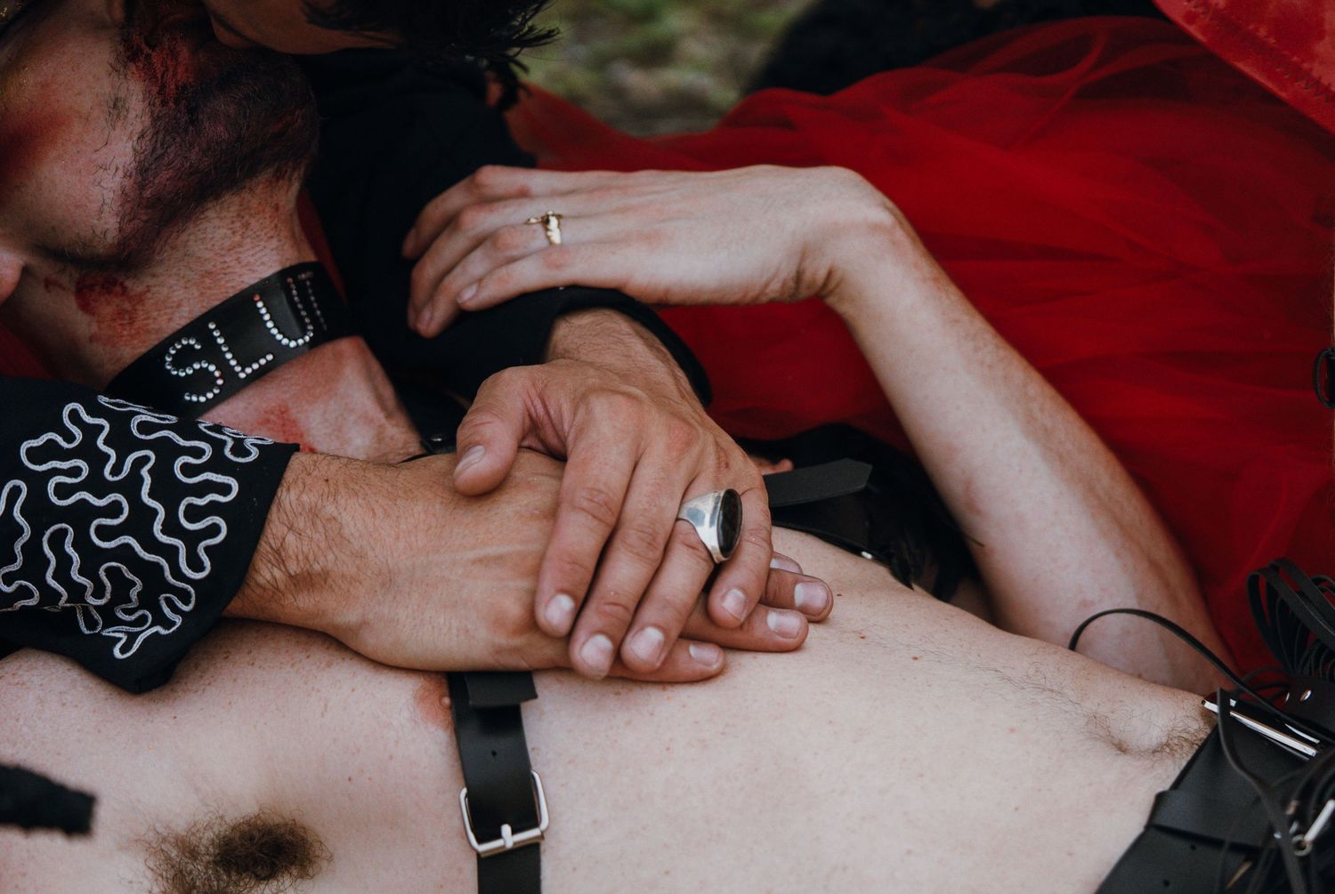 Close-up of two people holding hands tenderly during an intimate outdoor wedding ceremony moment.