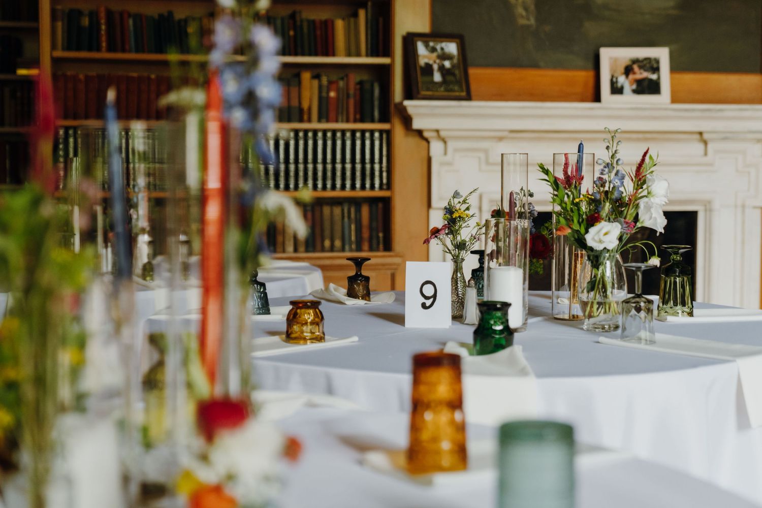 Elegant wedding reception table setup in a library with colorful floral arrangements and candles. New Orleans, Louisiana, Mississippi