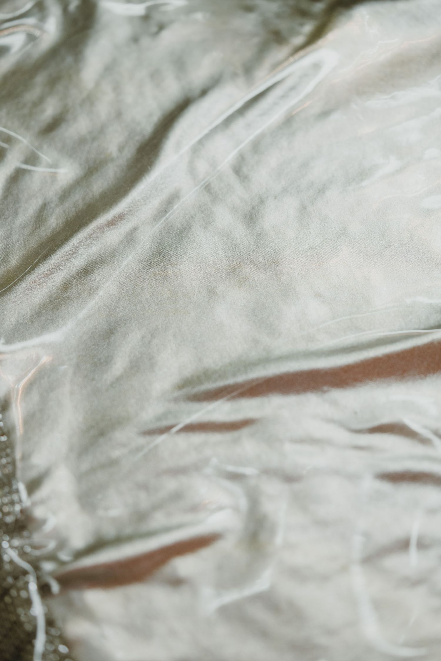 Close-up of delicate sheer white fabric with pearl embellishments from a traditional Indian wedding outfit.