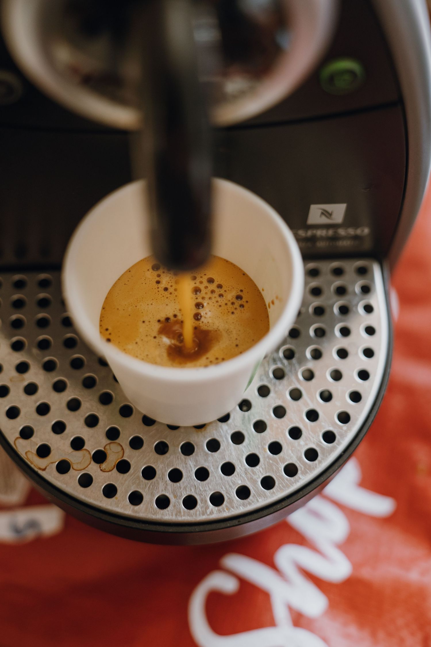 Close-up of a Nespresso espresso machine brewing a fresh shot of coffee into a small white cup. New Orleans, Louisiana, Mississippi