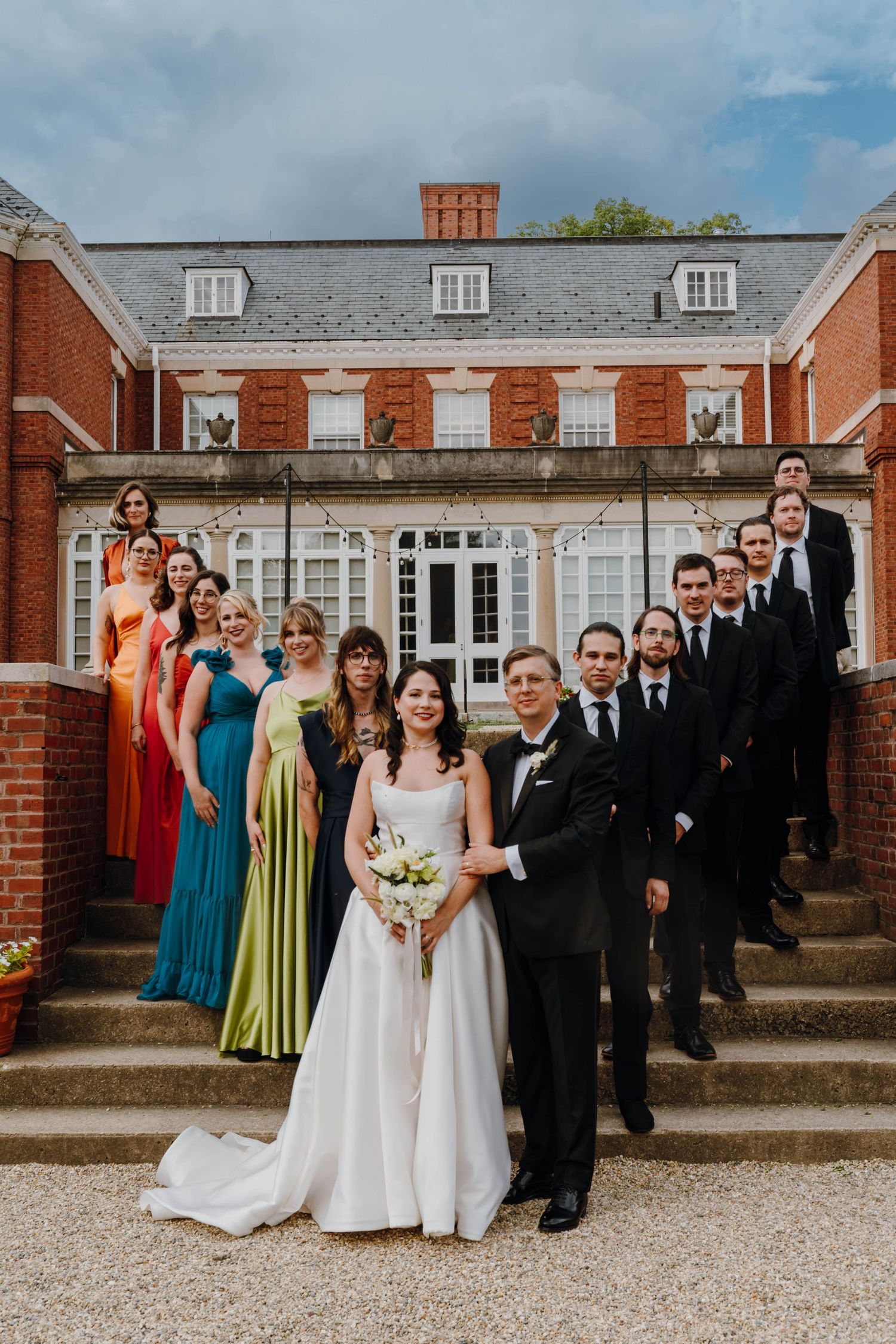 Wedding party posed on grand brick estate steps with bride and groom in center. New Orleans, Louisiana, Mississippi