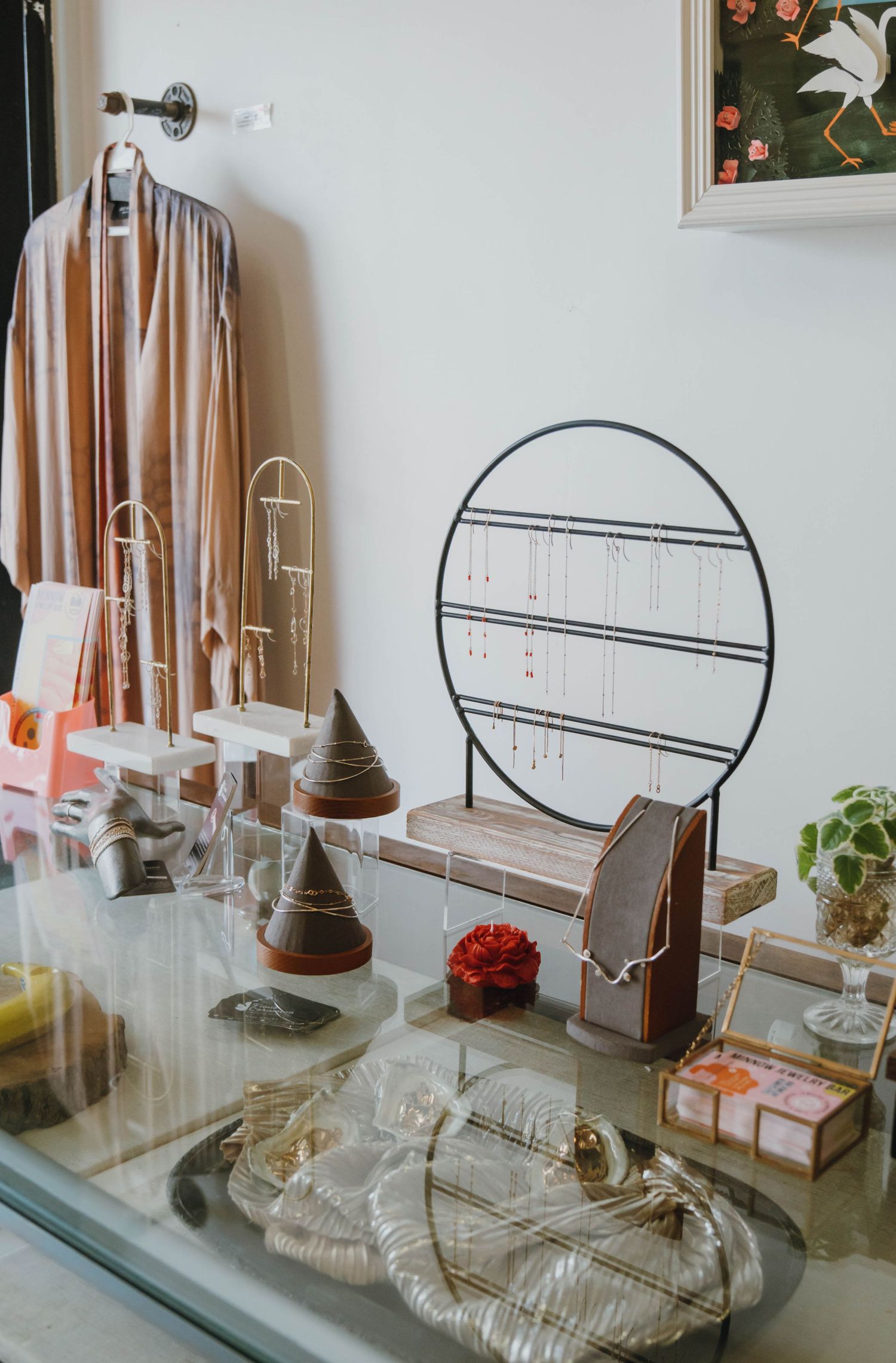 Elegant jewelry display with necklaces, earrings, and accessories on a glass counter in a boutique shop.