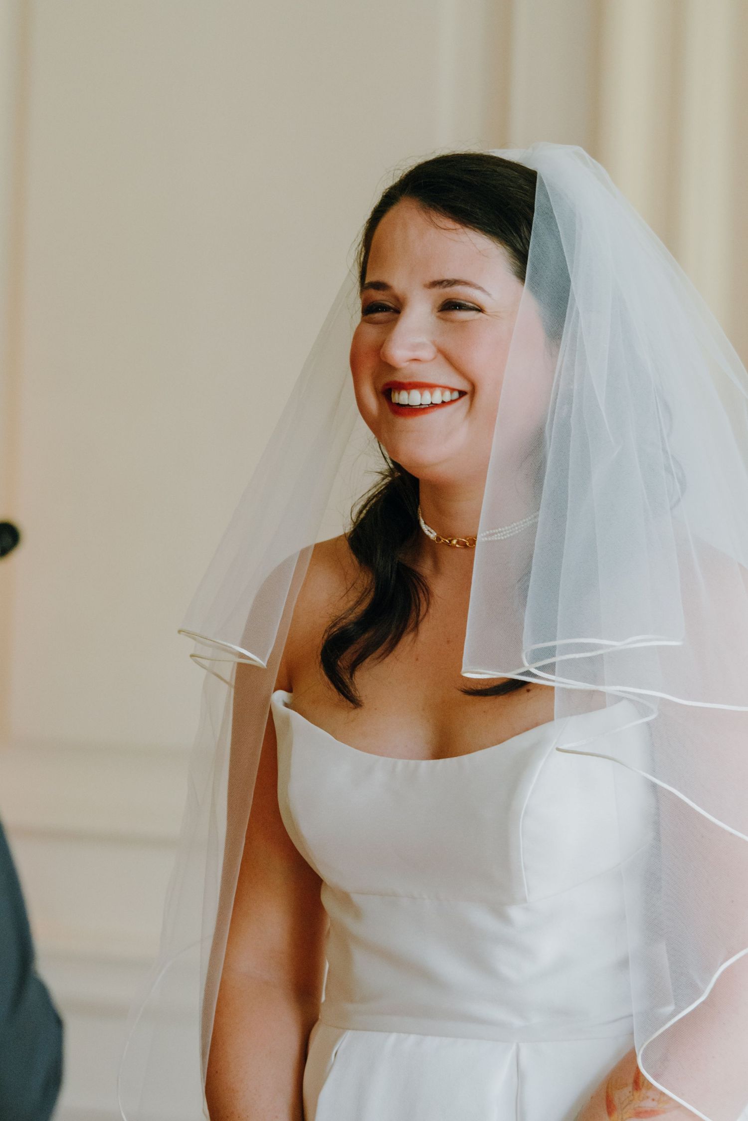 Radiant bride in strapless white gown and veil smiling joyfully during wedding ceremony. New Orleans, Louisiana, Mississippi