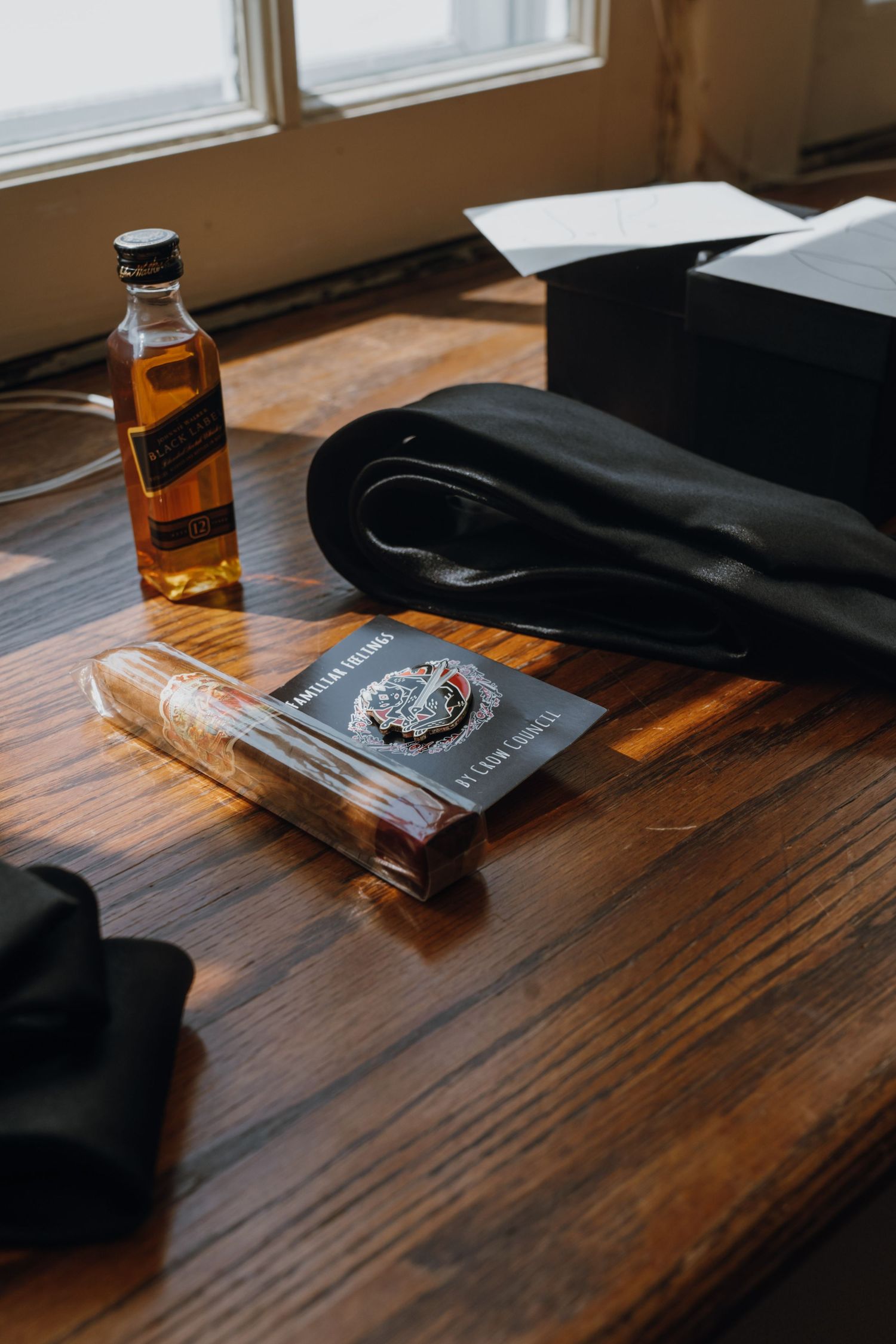 Groom gift flat lay with Johnnie Walker whiskey, cigar, book, and black bow tie on wooden table. New Orleans, Louisiana, Mississippi