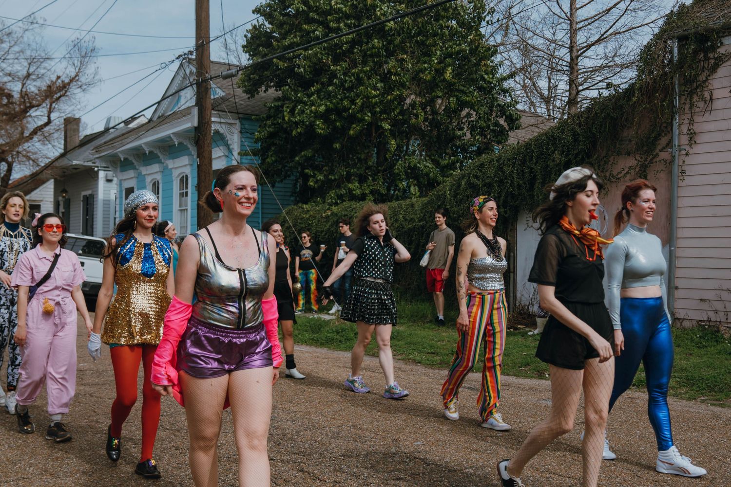 Colorful group of women in festive costumes walking together down a street.