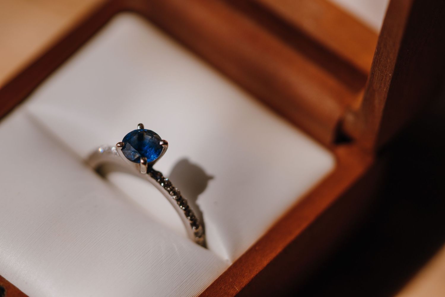 Elegant sapphire and diamond engagement ring displayed in a wooden jewelry box. New Orleans, Louisiana, Mississippi