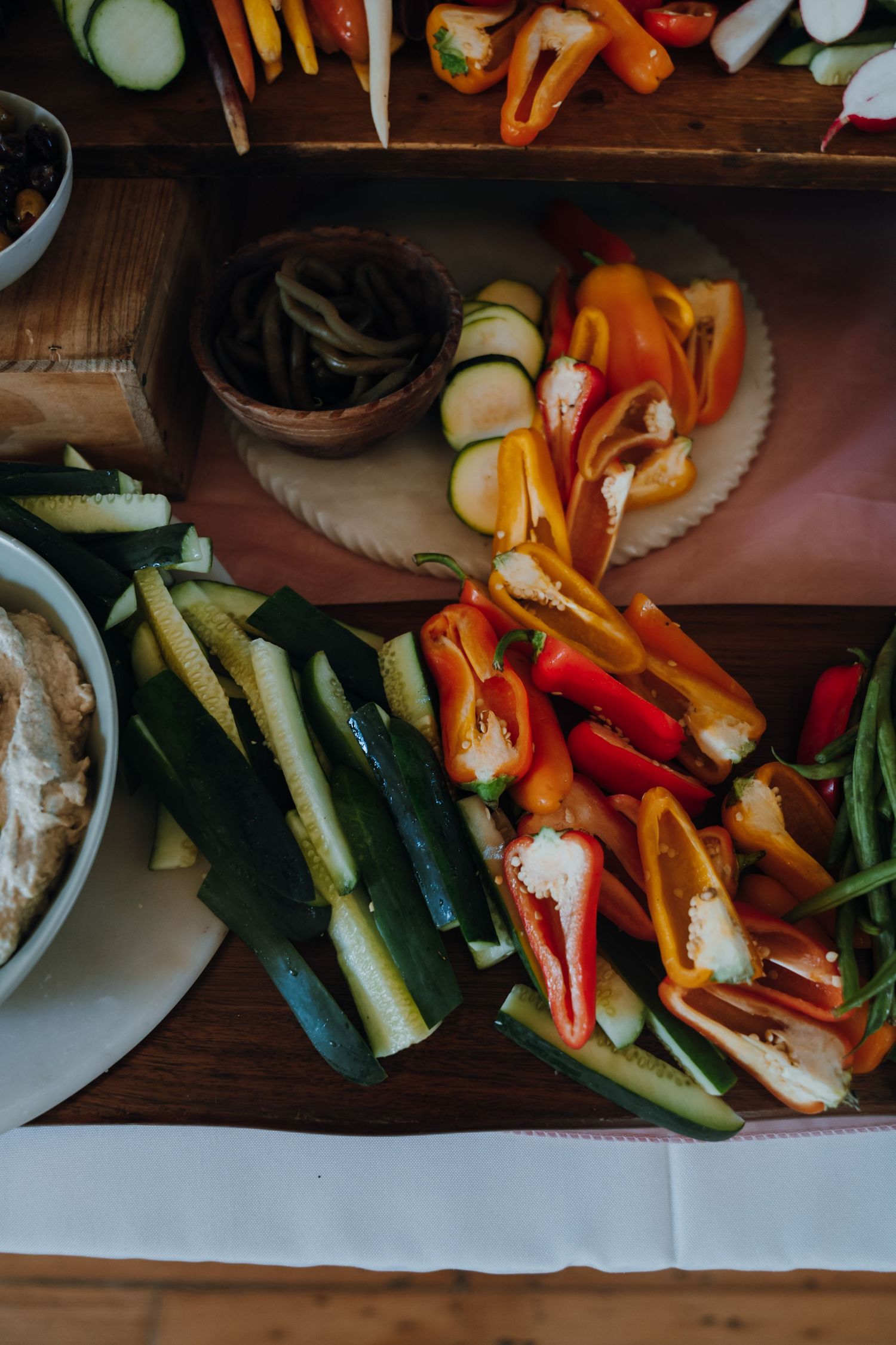 Colorful fresh vegetable crudite platter with peppers, zucchini, and dip at wedding reception.