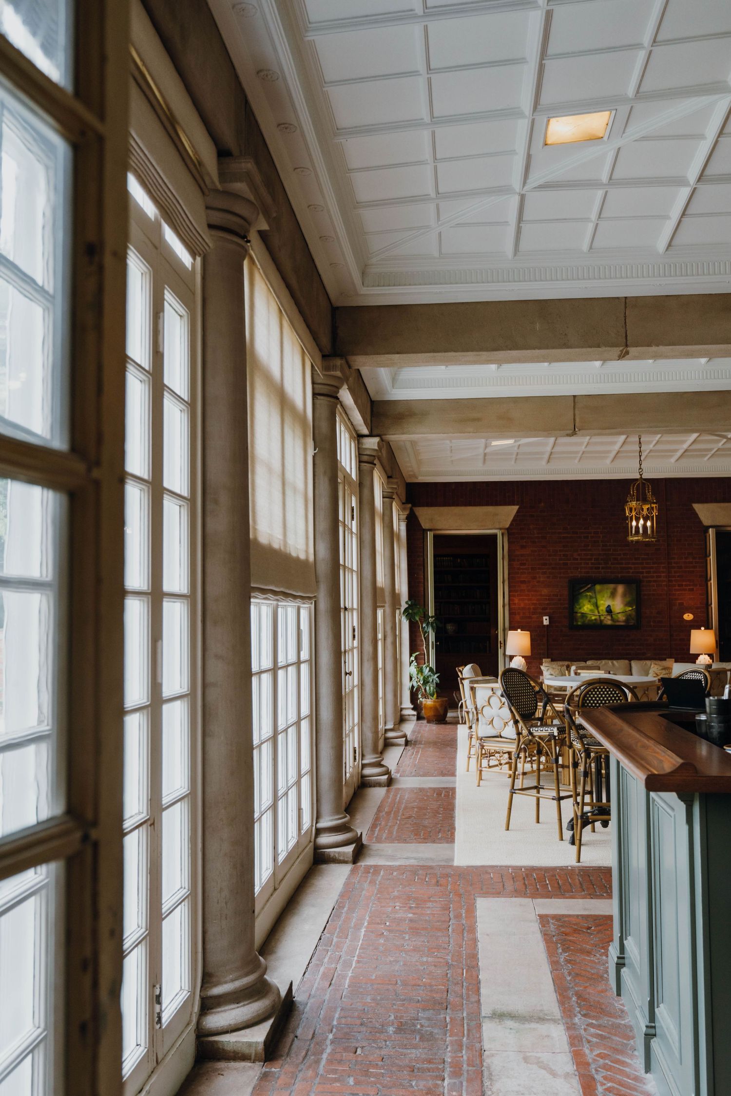 Elegant venue hallway with tall windows, ornate columns, coffered ceiling, and warm ambient lighting. New Orleans, Louisiana, Mississippi