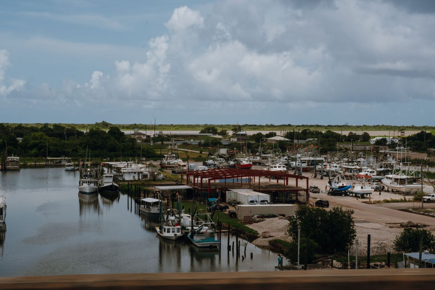 Aerial view of a marina with fishing boats docked along a calm waterway.