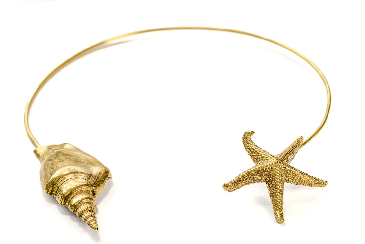 Gold open collar necklace featuring seashell and starfish charms on white background.