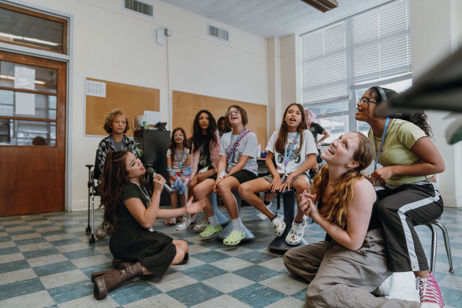 Diverse group of teenage girls laugh and socialize together seated in a school hallway. New Orleans, Louisiana, Mississippi