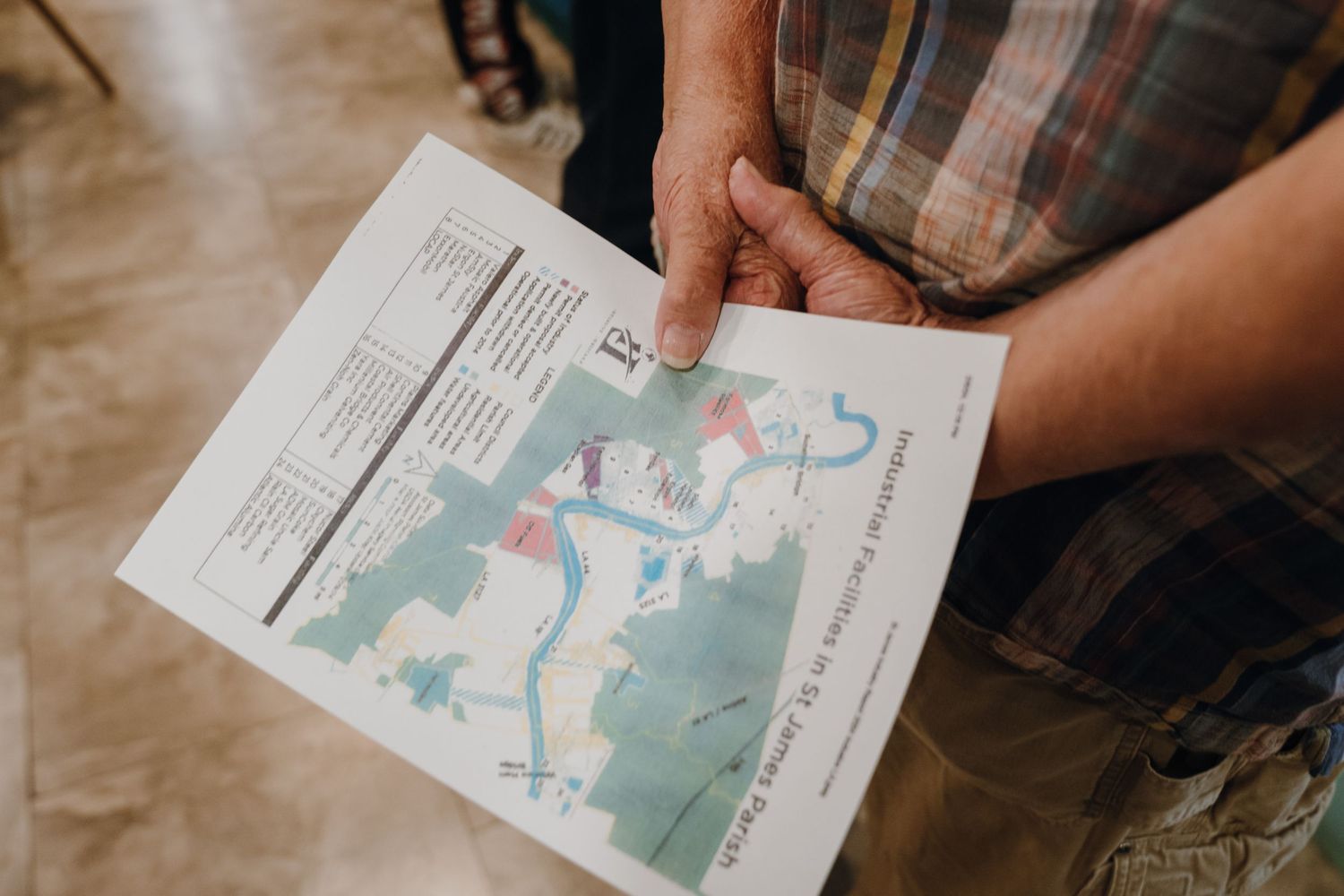 Person holding a community map flyer with trail routes and information at a local planning event.
