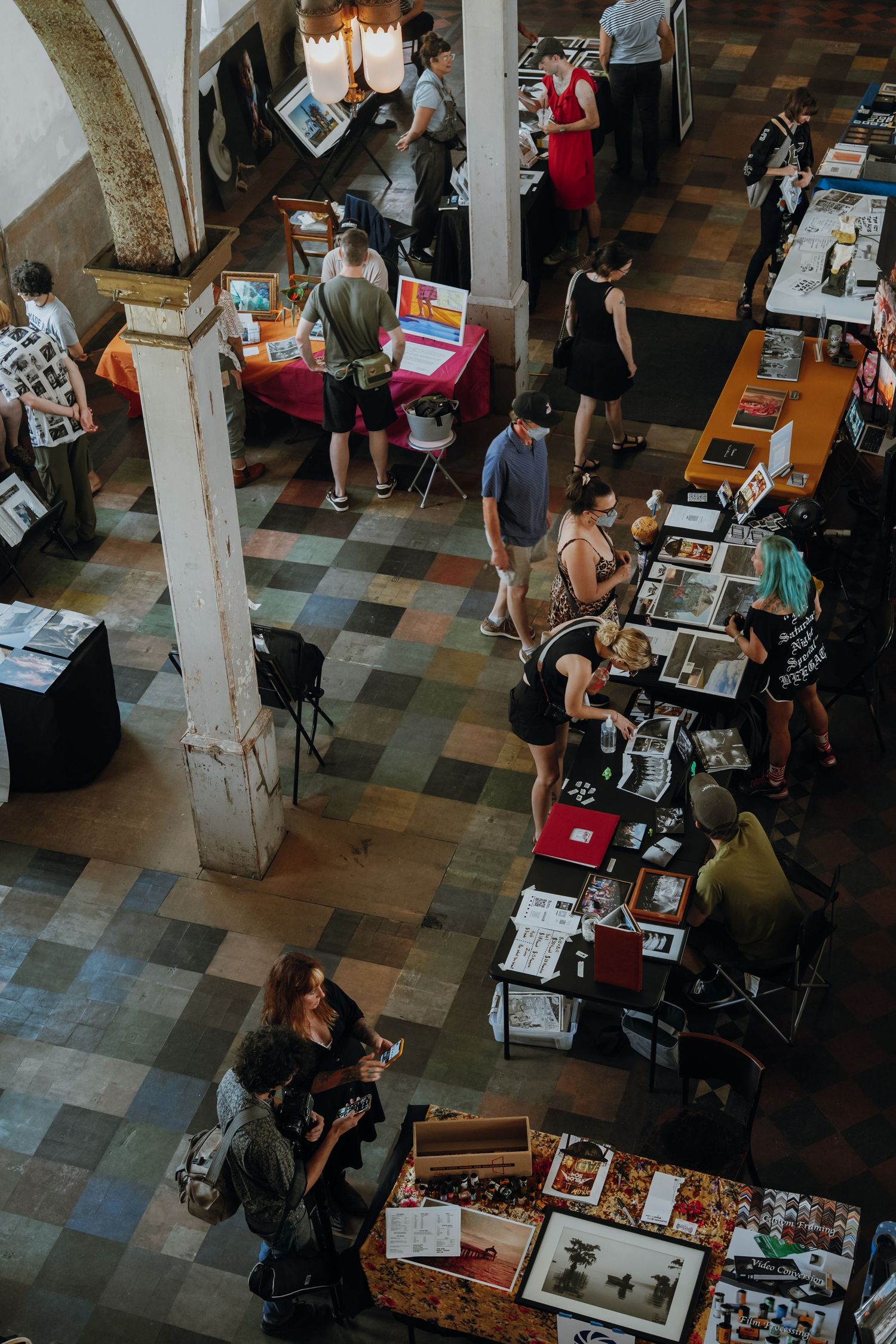 Aerial view of people browsing vendor tables at an indoor art and photography fair. New Orleans, Louisiana, Mississippi