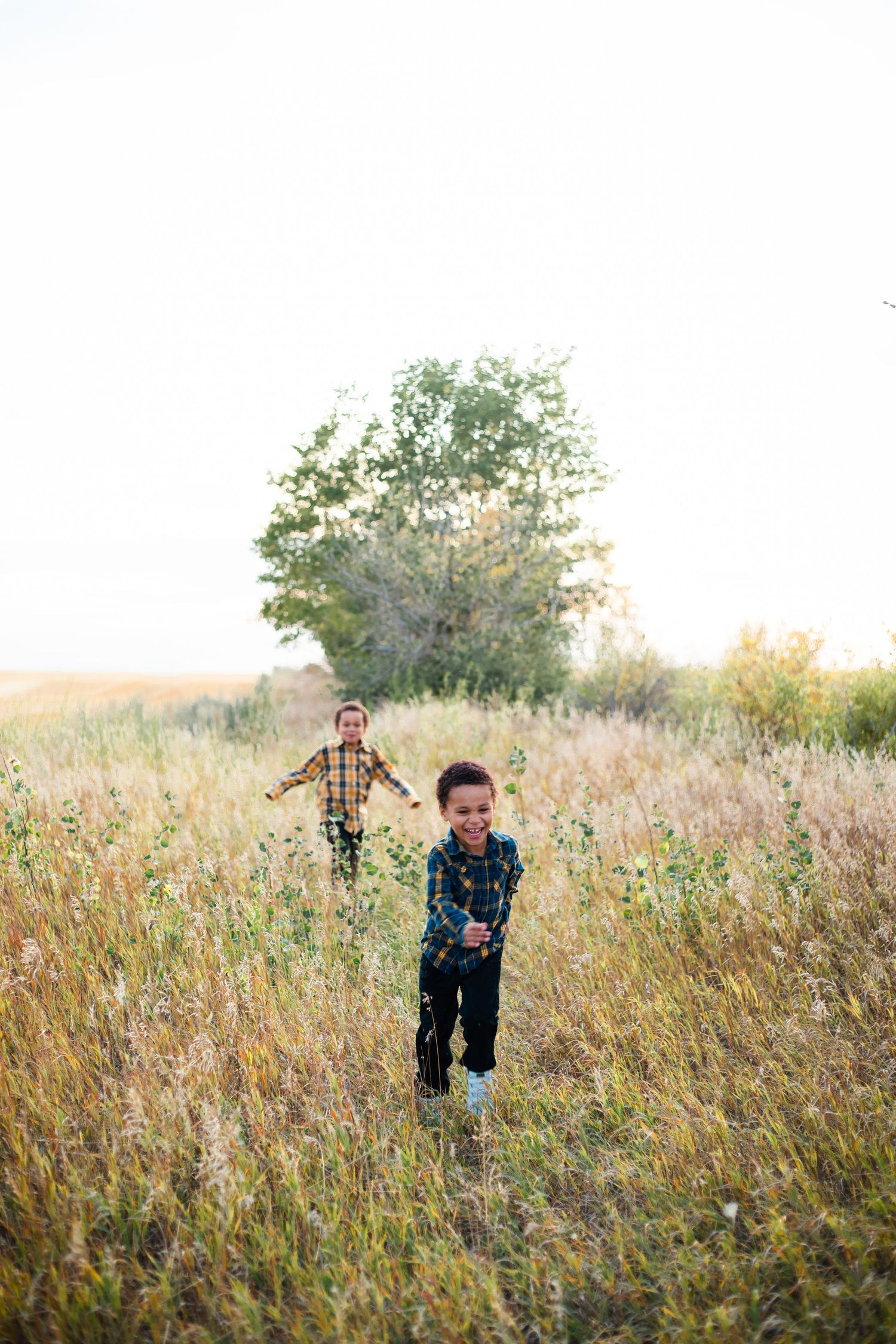 Family laughing outdoors during a lifestyle photography session in Alberta
