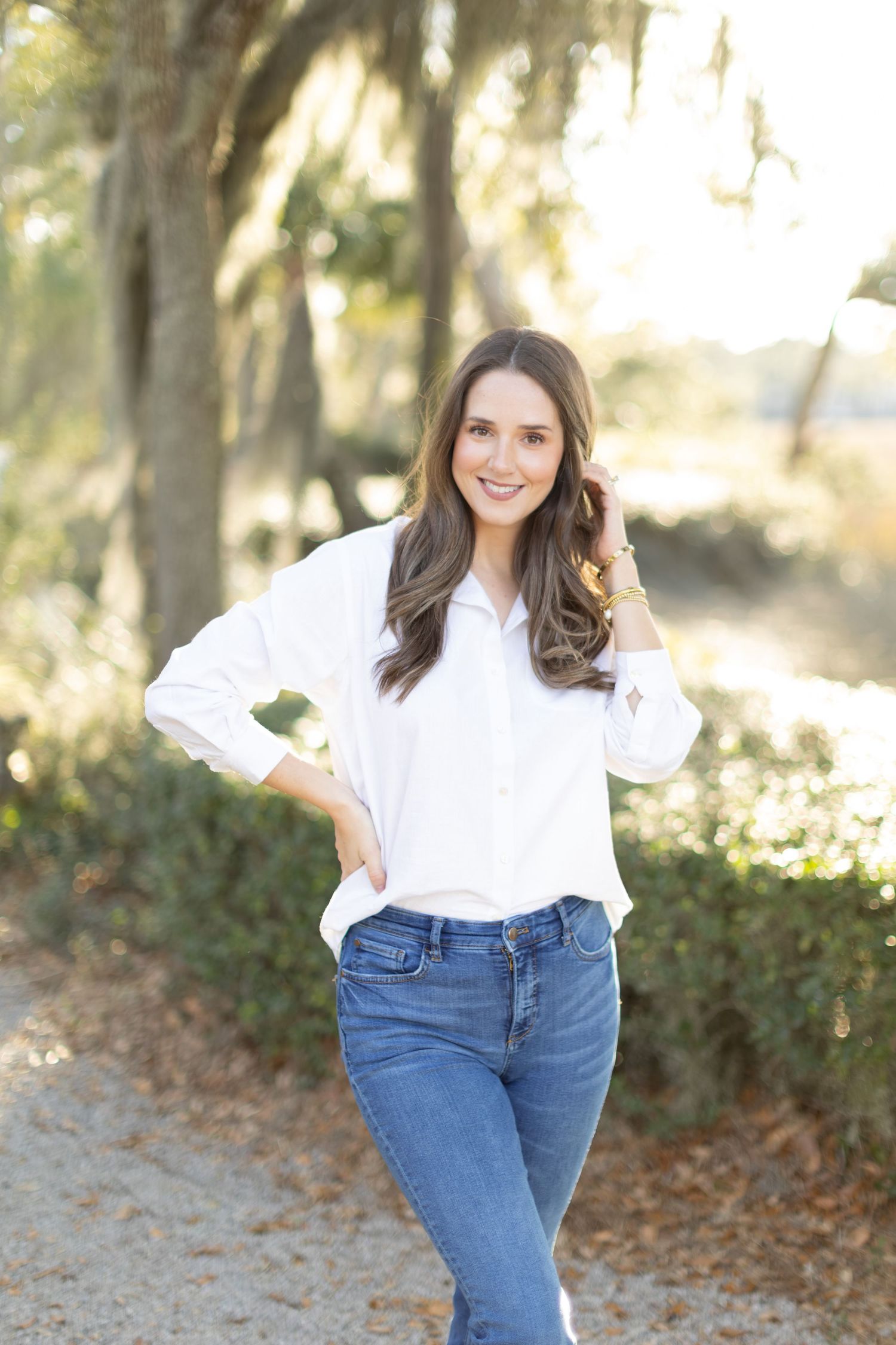A casual outfit featuring a white button-down shirt and blue jeans shown in multiple outdoor poses.