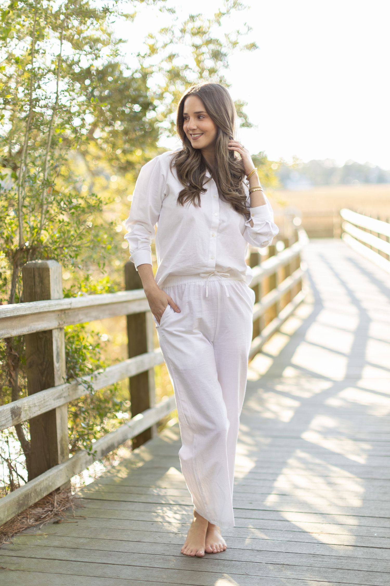 A series of photos showing someone in a white dress walking barefoot on a wooden boardwalk during golden hour.