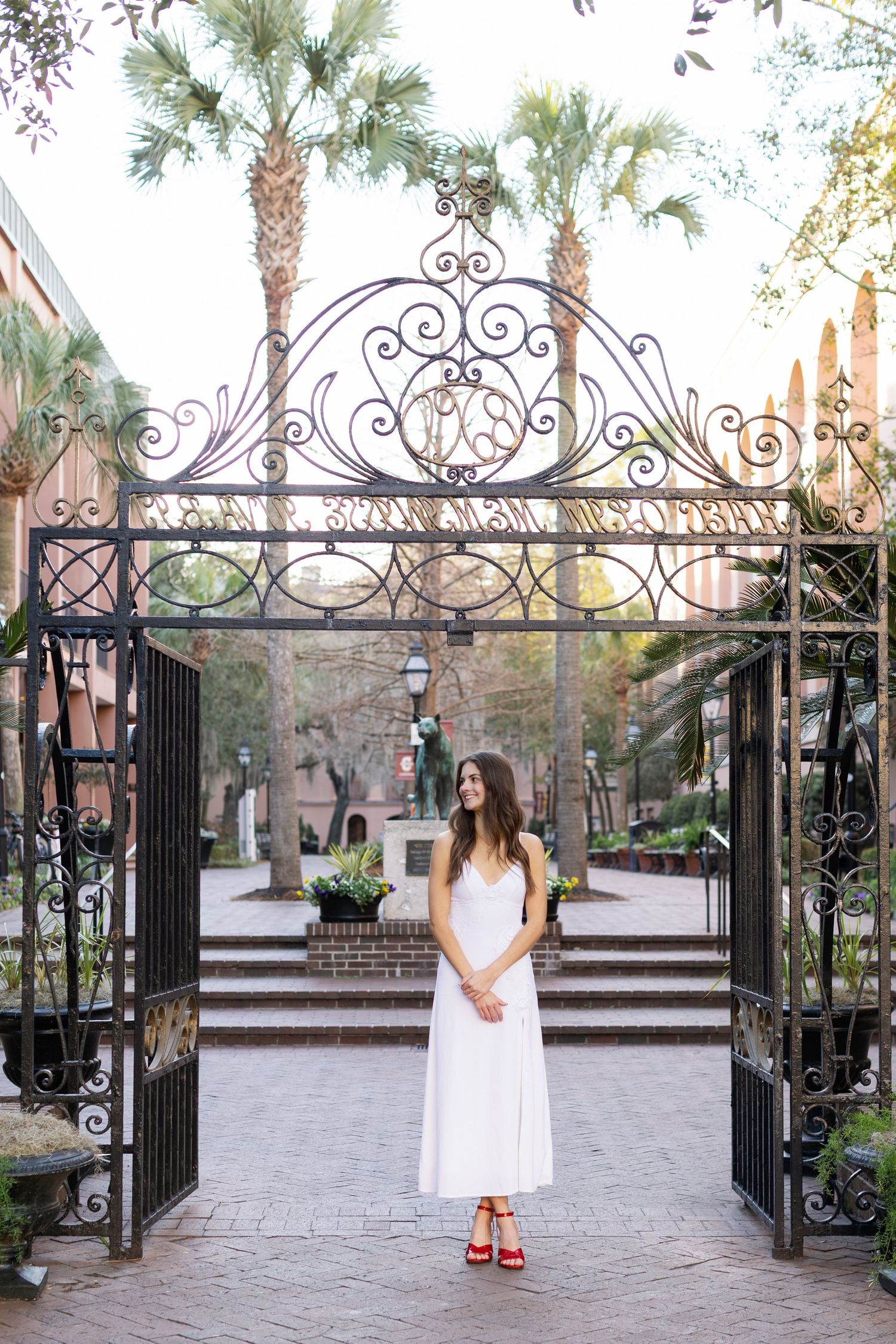 A sequence of photos showing a person in a white dress standing at an ornate wrought iron garden gate with palm trees.