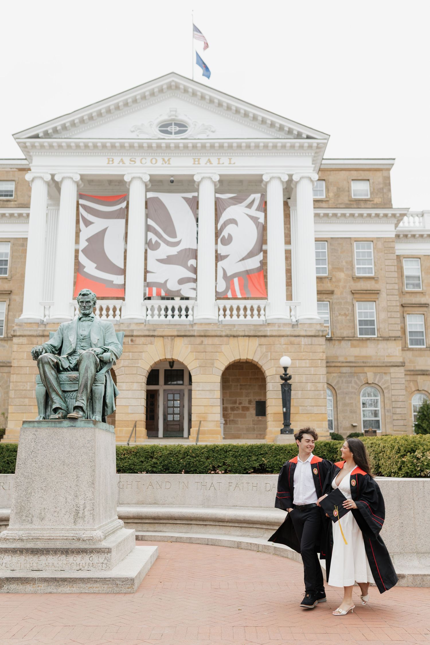 Graduation portraits taken in front of historic university building with white columns and pediment.
