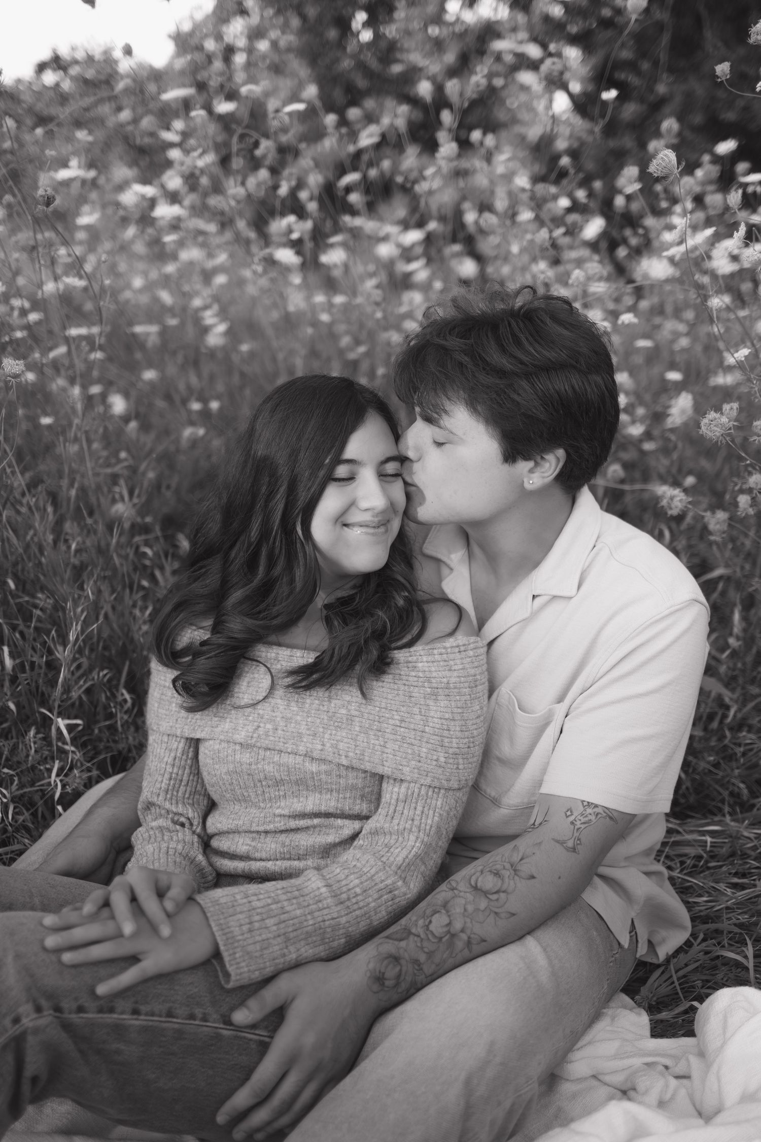 Intimate black and white photos of a couple relaxing in a flower field.