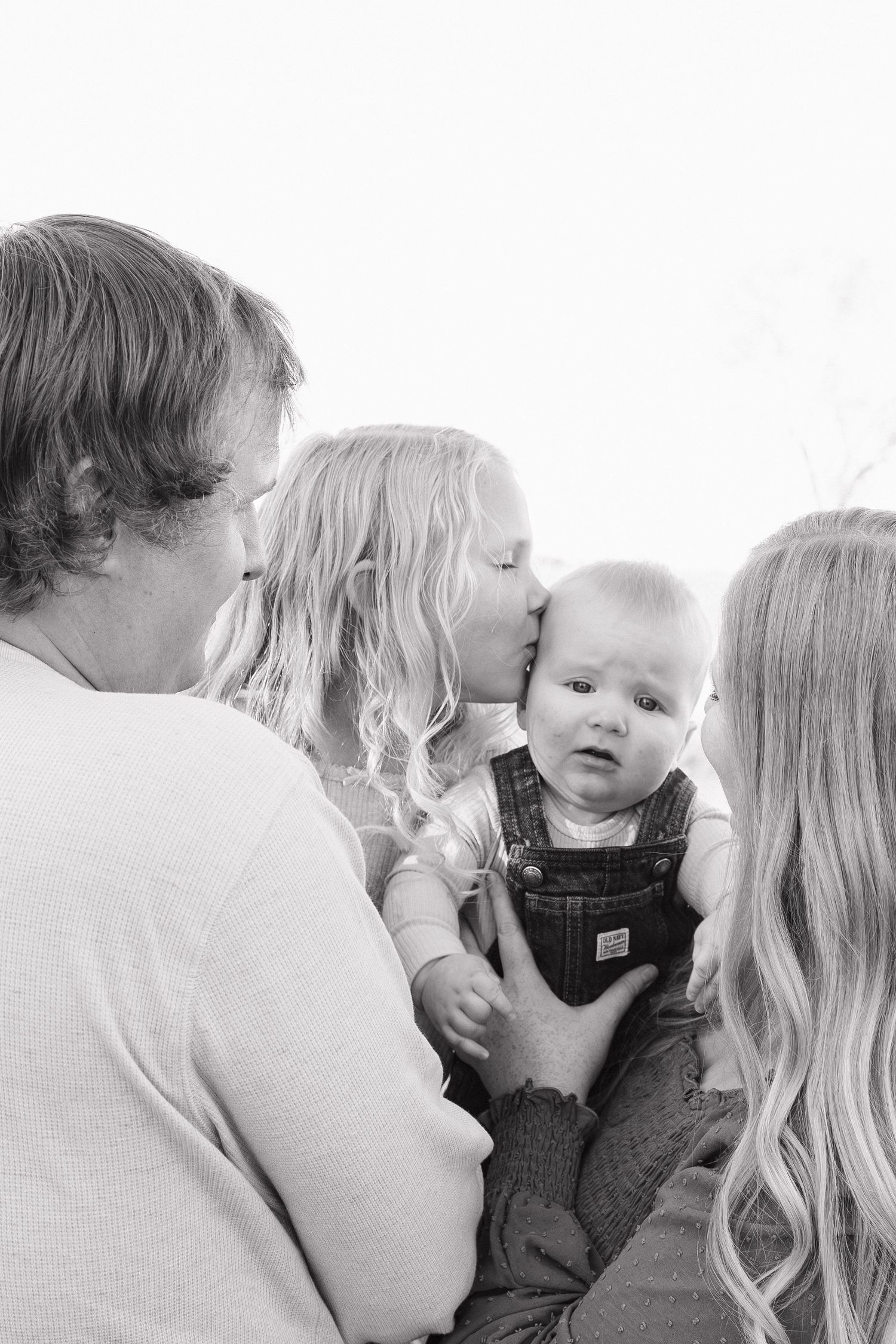 Intimate black and white family portrait series showing tender moments and connections.