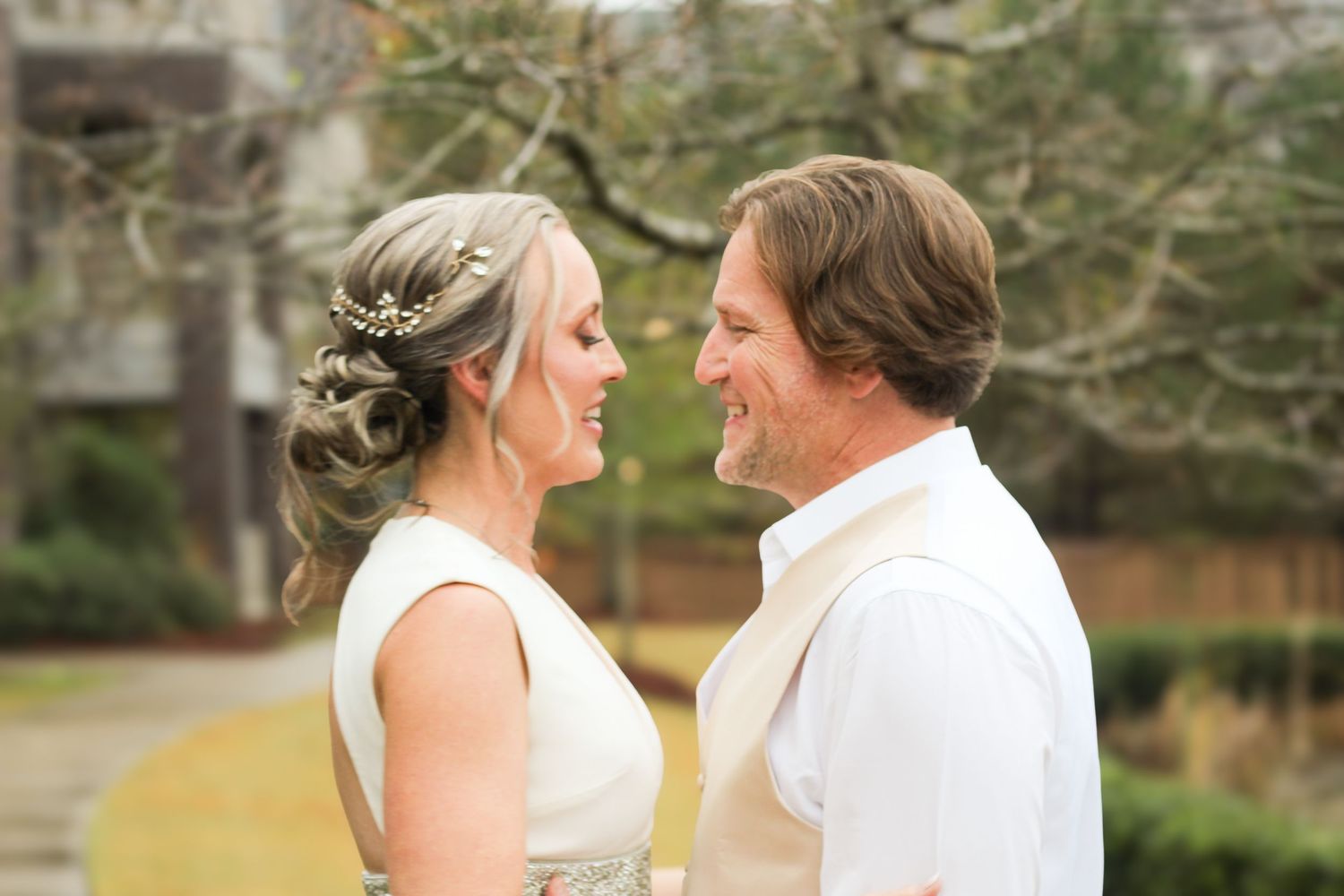 A couple shares tender moments in wedding attire during an outdoor photo session.
