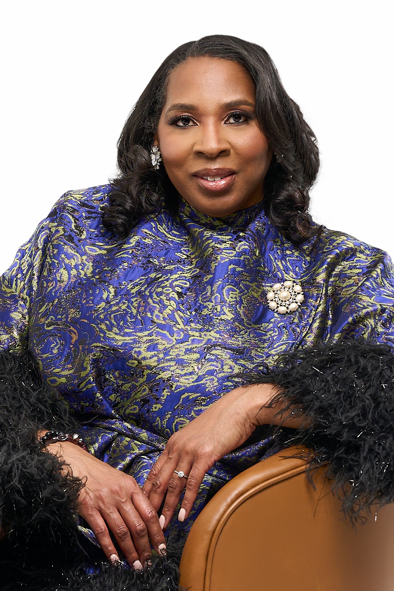Professional portrait series in blue brocade dress with feather boa against dark background.