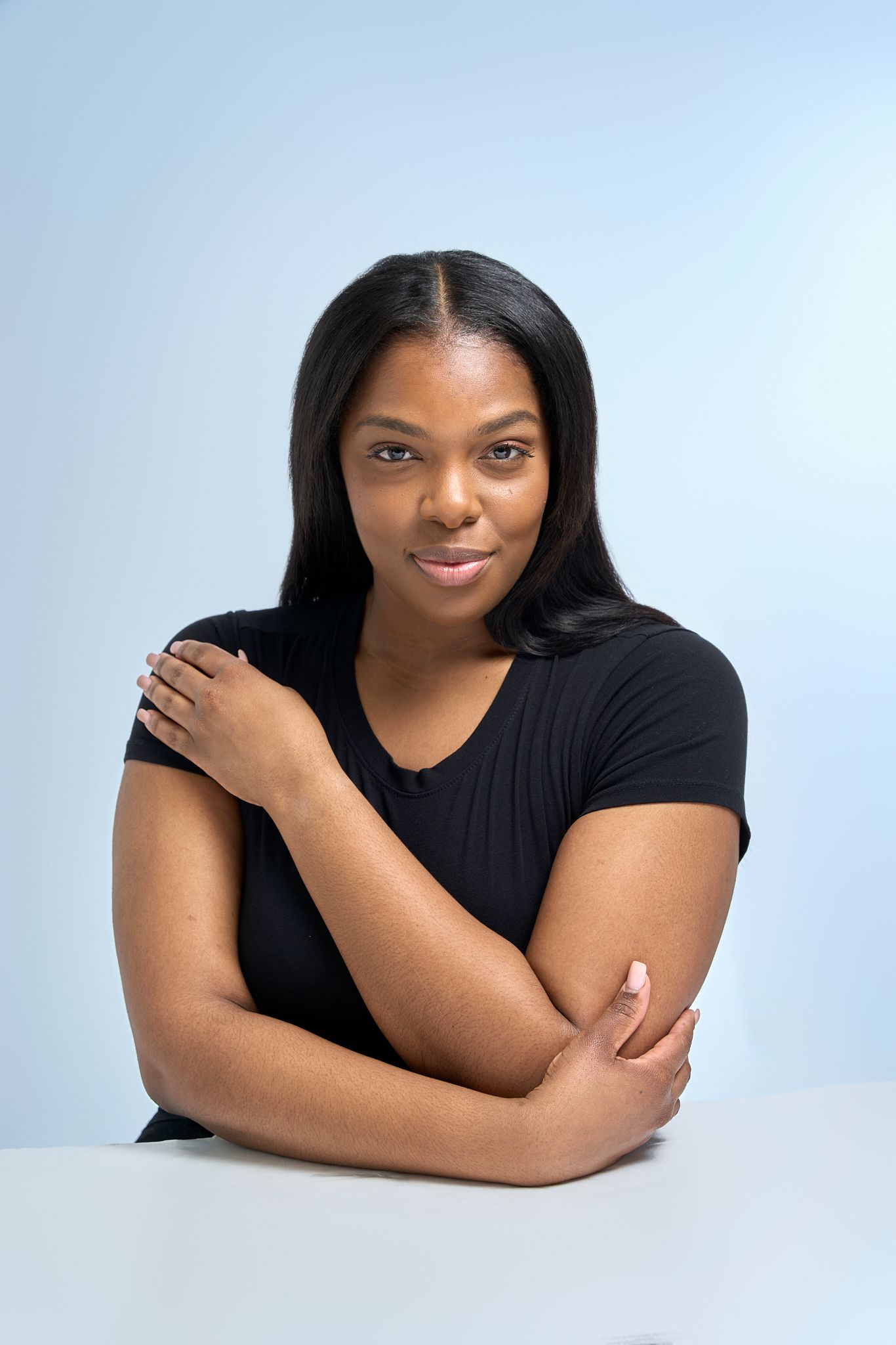 Professional studio portrait series showing a person in a black top against a light background in four different poses.