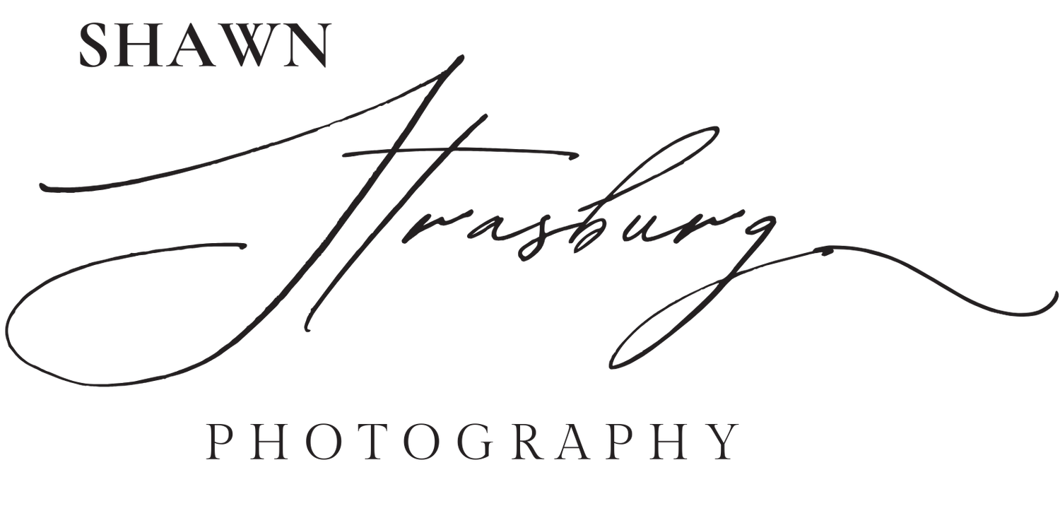 Elegant black and white text logo design for a photography business with a stylized signature and cursive font.