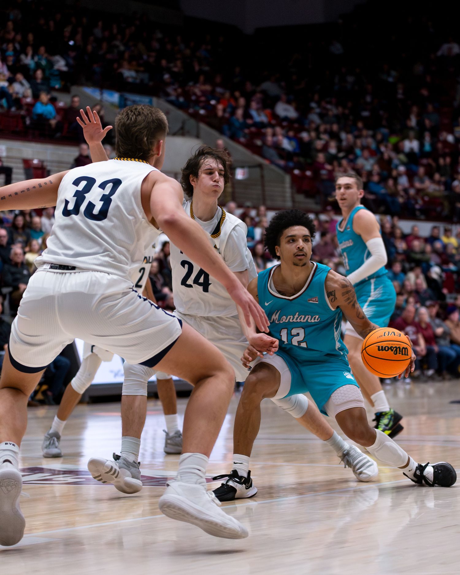 Players from opposing teams compete for position during an intense basketball game.