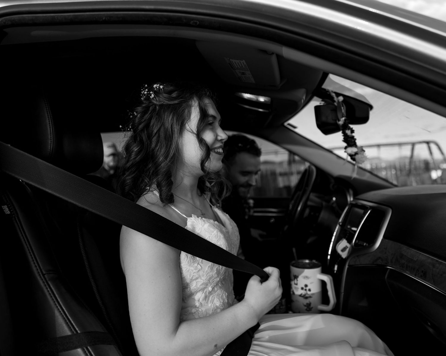 A sequence of black and white photos showing someone drinking from a bottle while sitting in the driver's seat of a car.