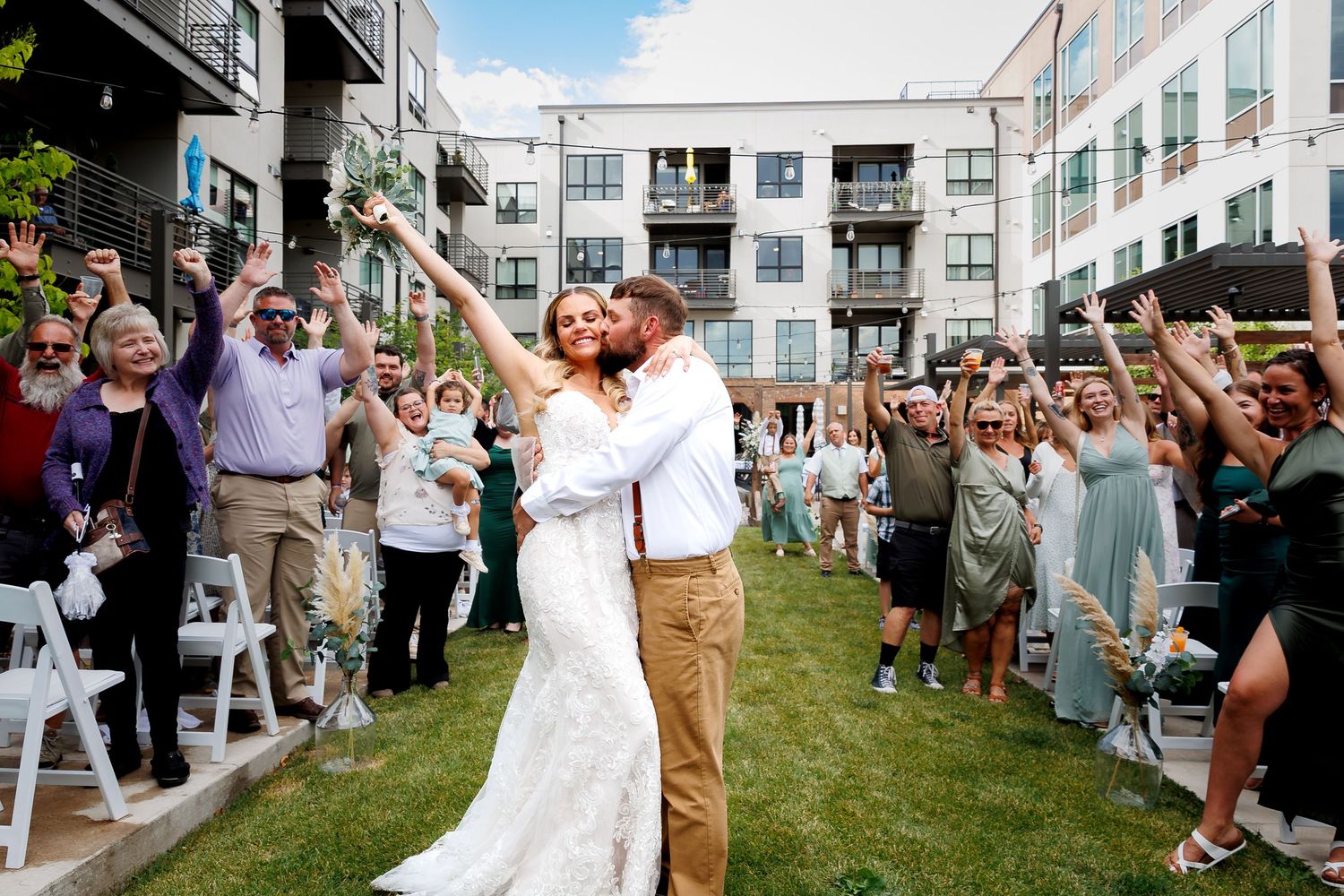 Wedding guests gather outside Cambium in Missoula Montana on a lawn to celebrate during a summer outdoor reception ceremony.