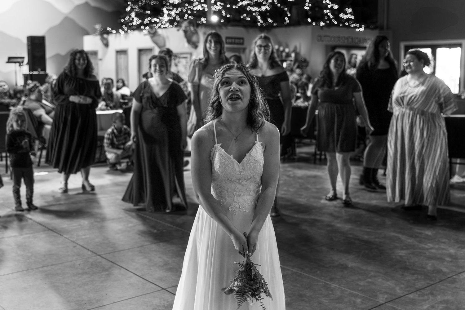 Black and white photo of a bride laughing joyfully on the dance floor during a wedding reception.
